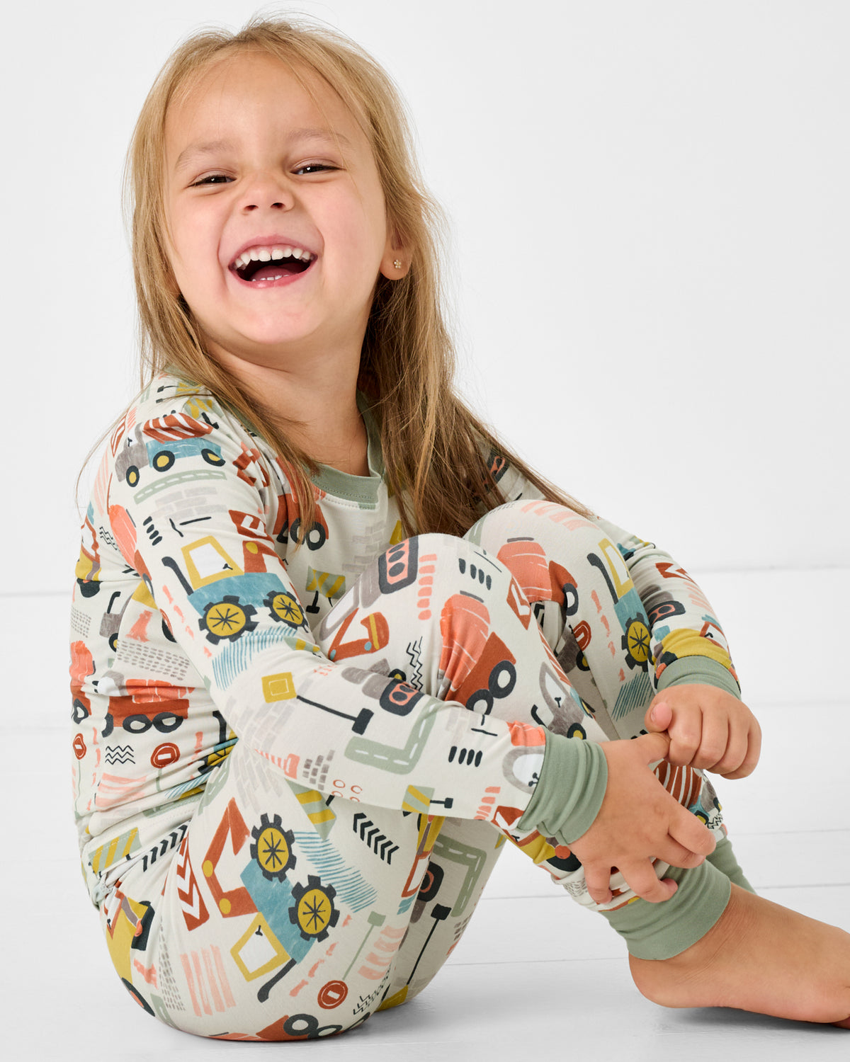 Sitting girl wearing the Mini Builders Two-Piece Construction themed PJ Set