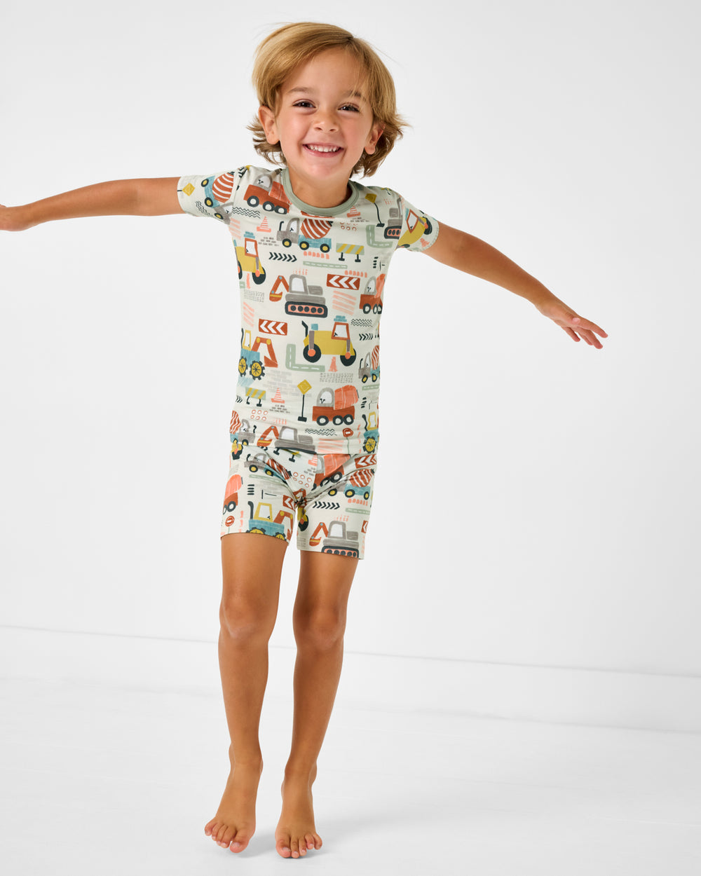 Jumping boy wearing the Mini Builders Two-Piece Short Sleeve & Shorts Pajama Set
