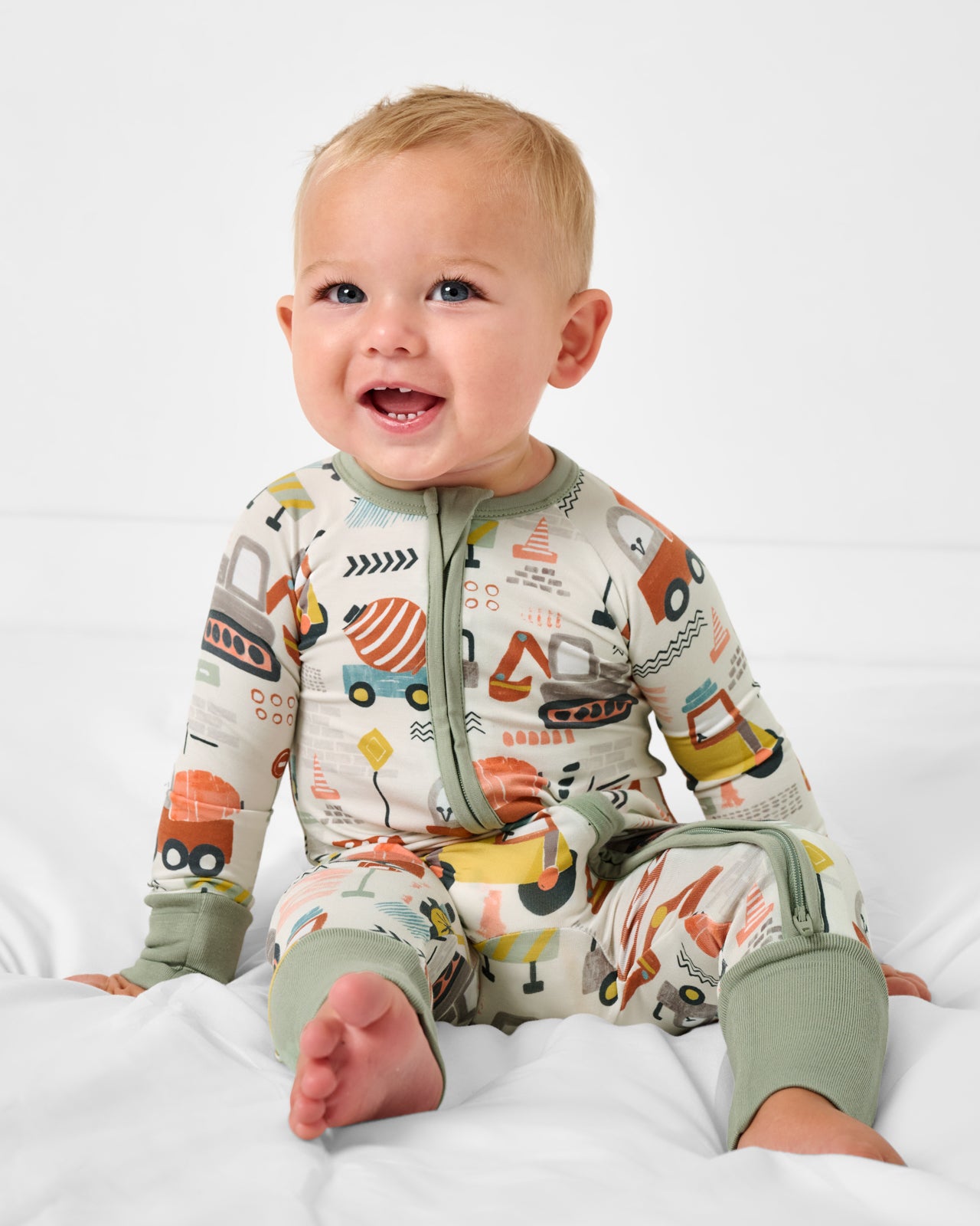 Sitting baby wearing the Mini Builders Zippy
