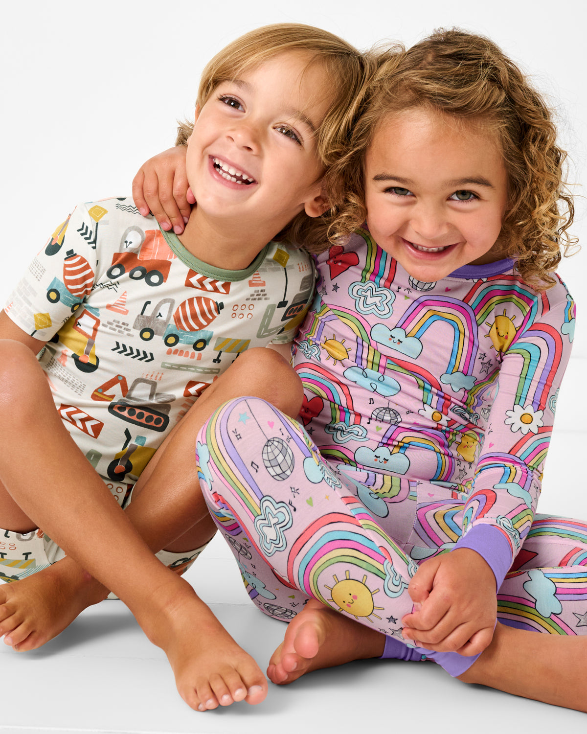 Two children wearing Mini Builders and Disco Rainbows Two-Piece PJ Sets
