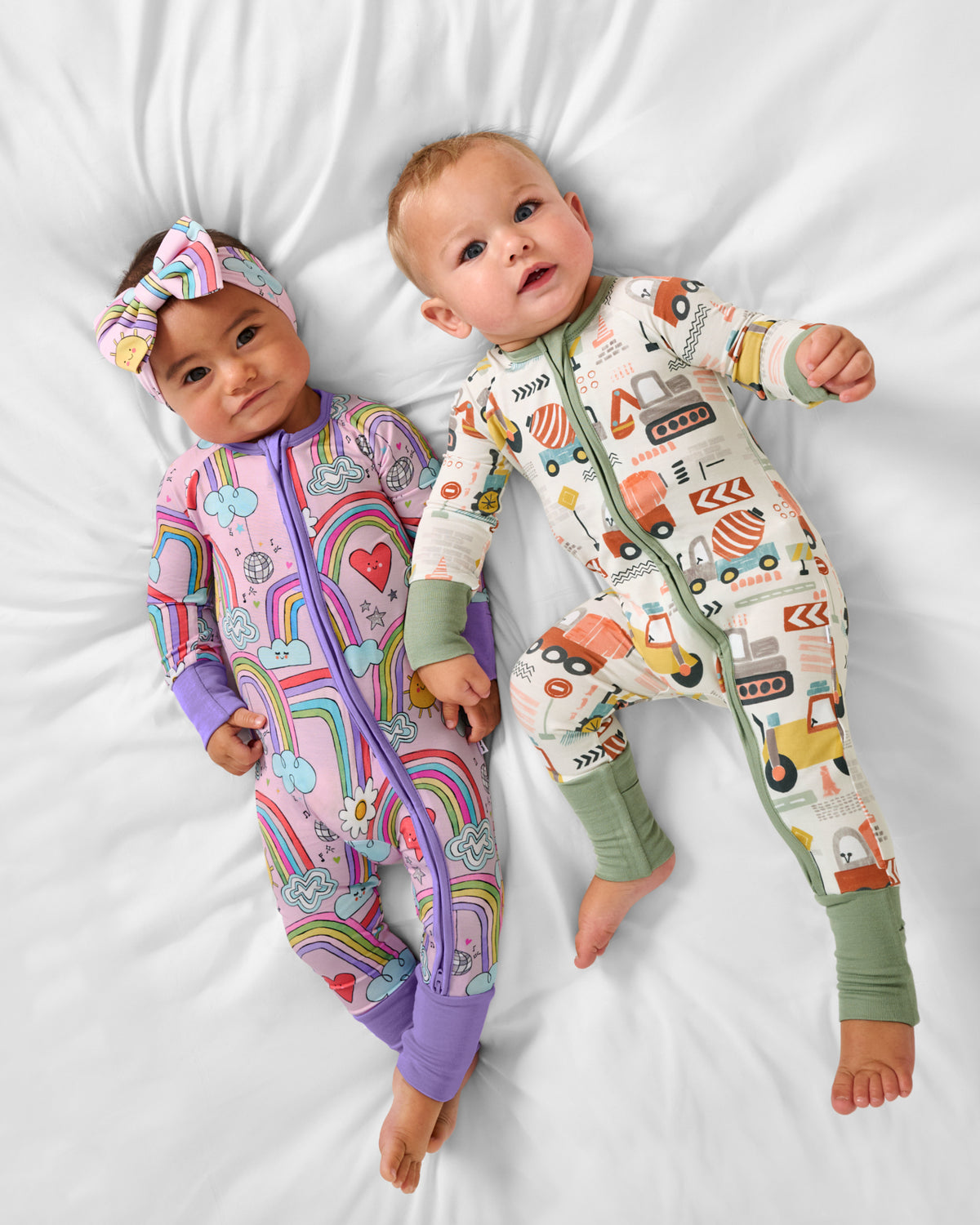 Aerial view of two babies wearing Rainbow Disco and Mini Builders zippies