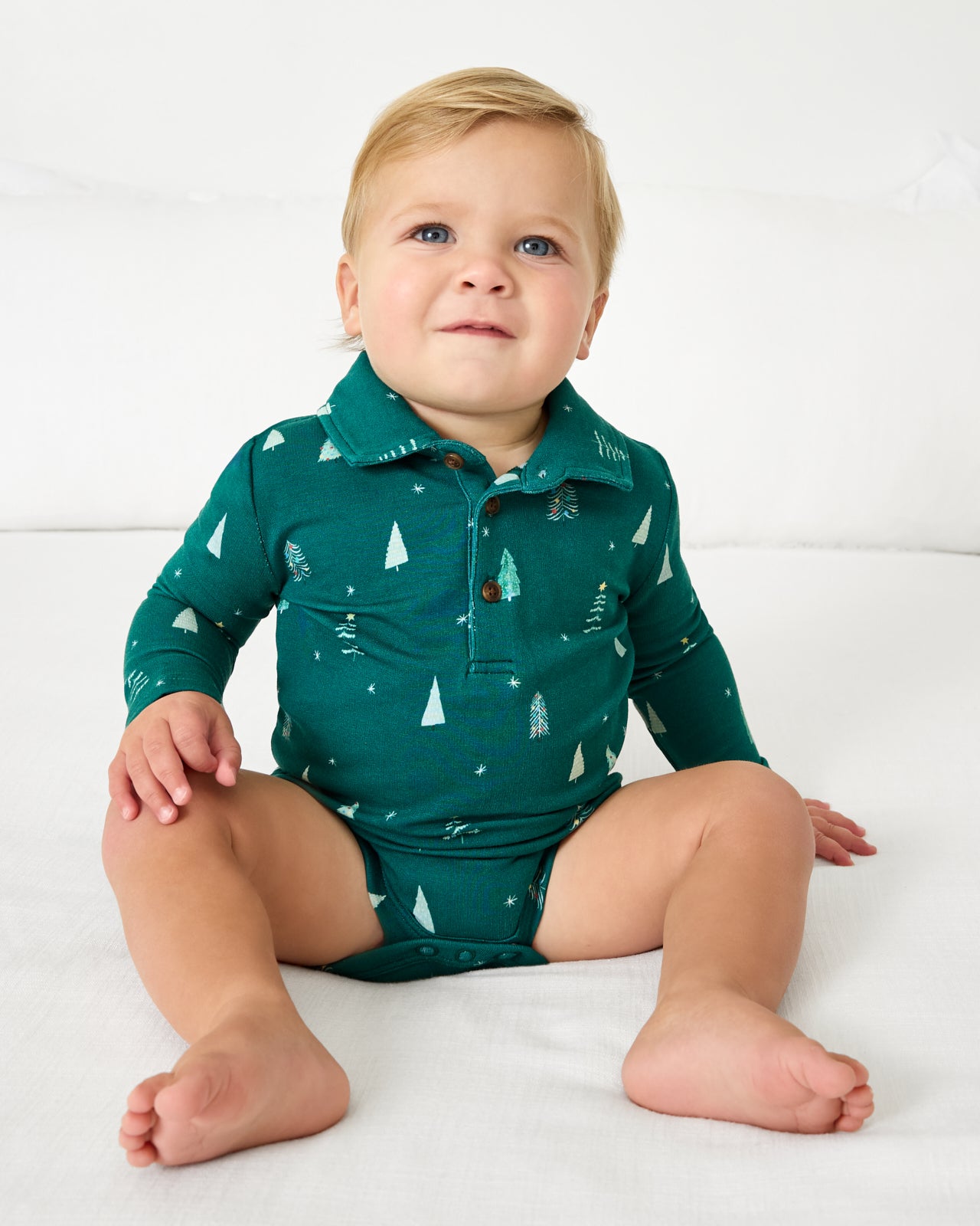 Baby wearing the Twinkling Trees Polo Bodysuit