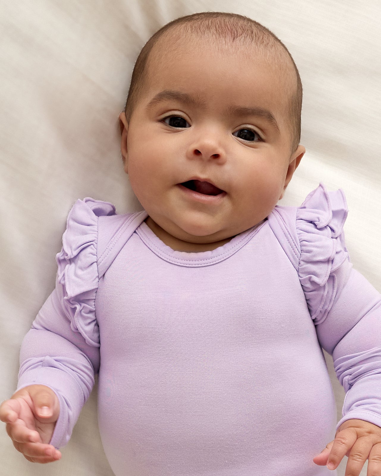 Close up of newborn wearing the Misty Lavender Flutter Bodysuit