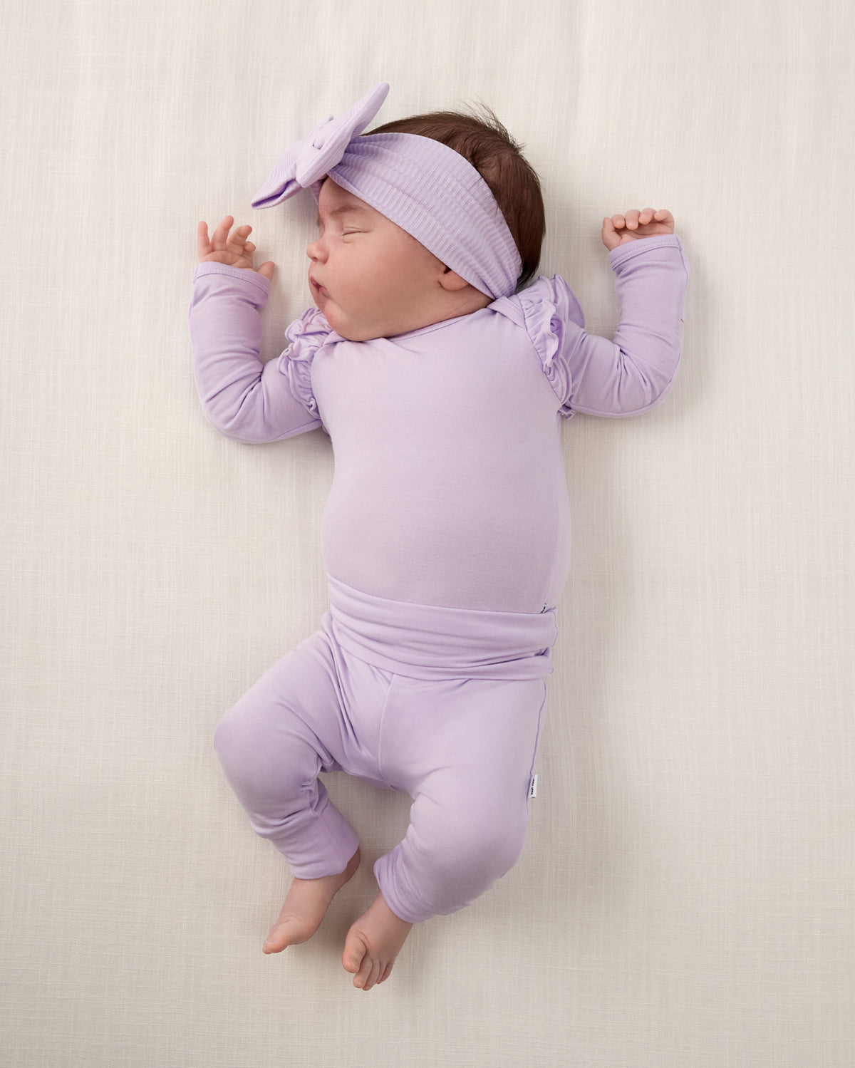 Aerial view of newborn wearing the Misty Lavender Ribbed Luxe Bow Headband with a matching outfit