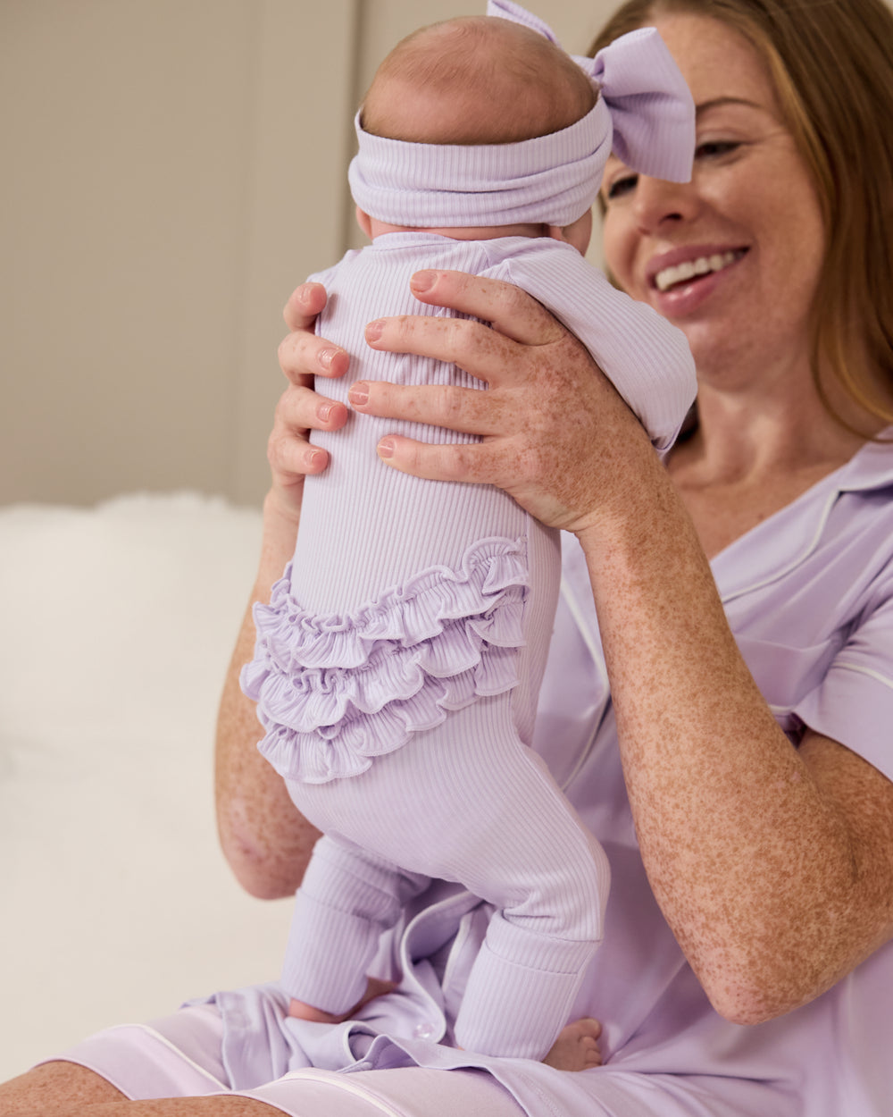 Woman wearing the Misty Lavender Women's Pajama Set holding newborn