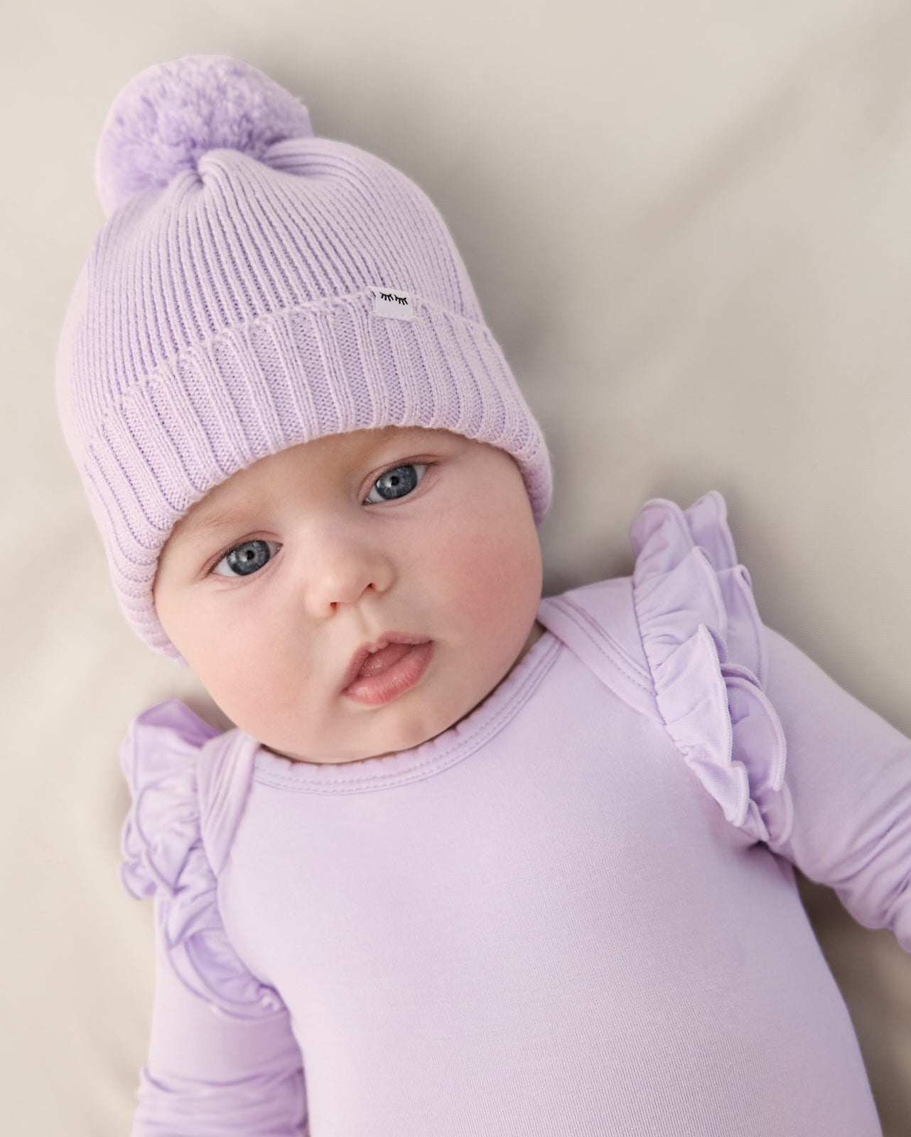 Newborn wearing the Misty Lavender Sweater Beanie Hat with a matching bodysuit