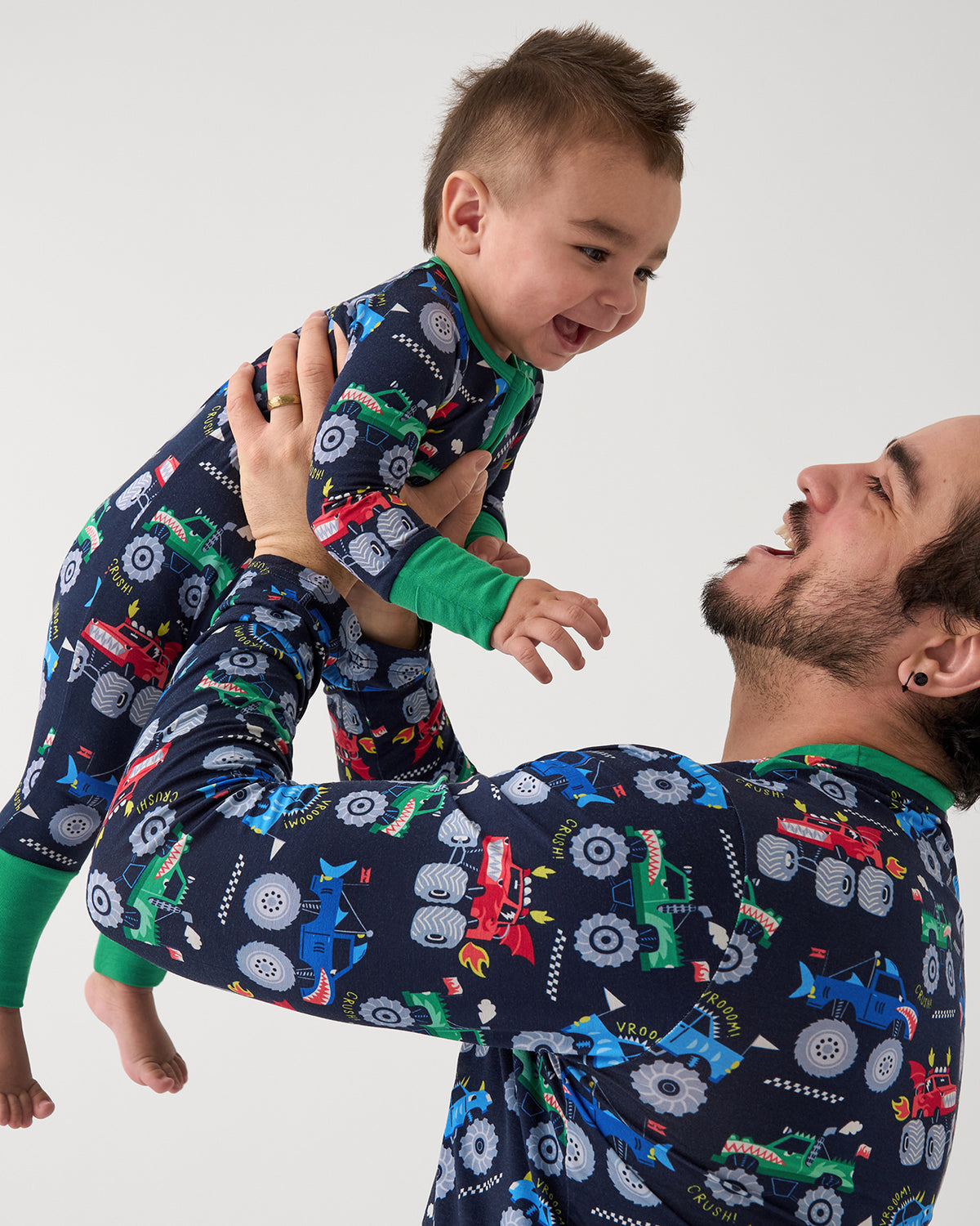 Father and son wearing matching Monster Truck Madness pajamas
