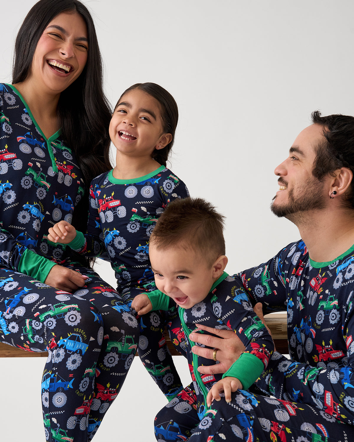 Family of four wearing matching Monster Truck Madness Pajamas