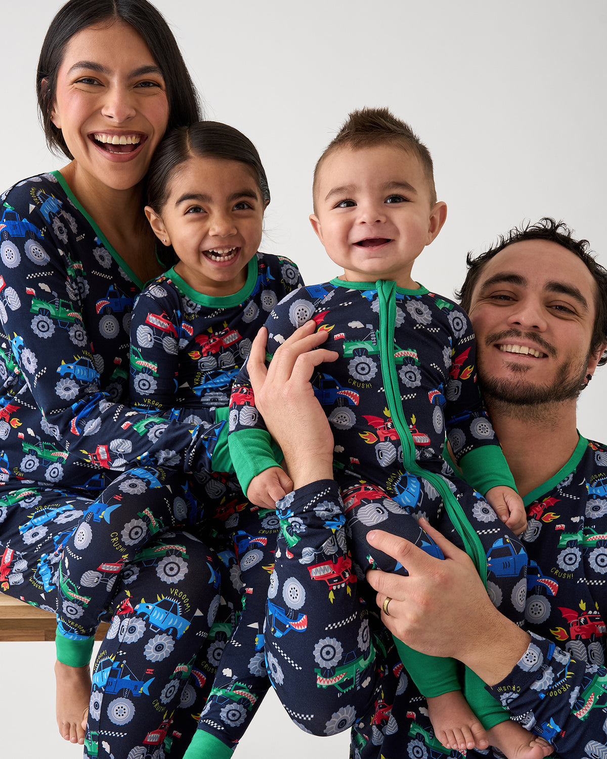 Family of four wearing matching Monster Truck Madness pajamas