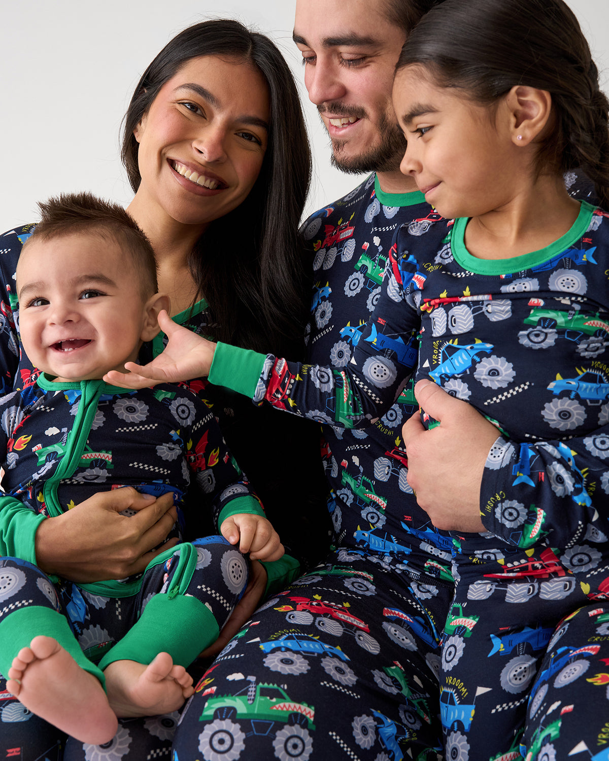 Family of four wearing matching Monster Truck Madness bamboo pajamas