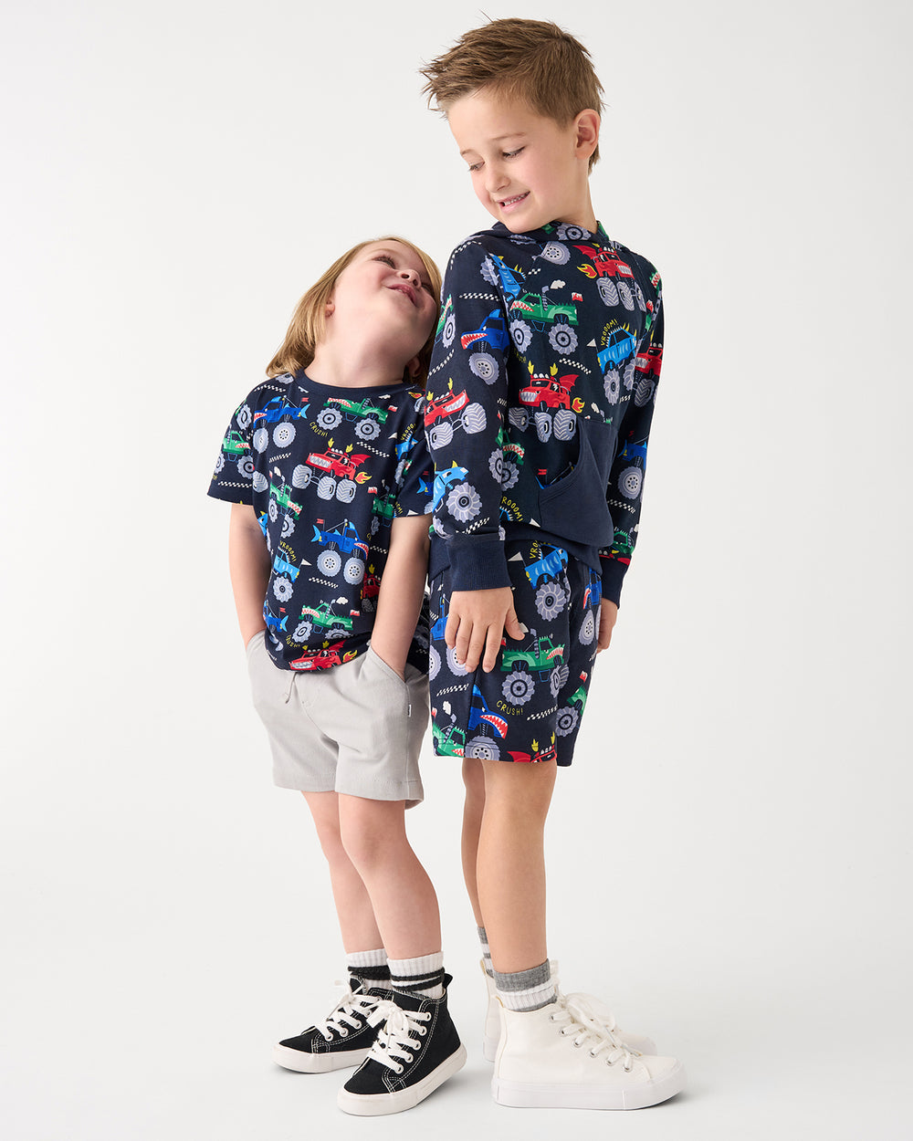 Two children wearing matching Monster Truck Madness play styles
