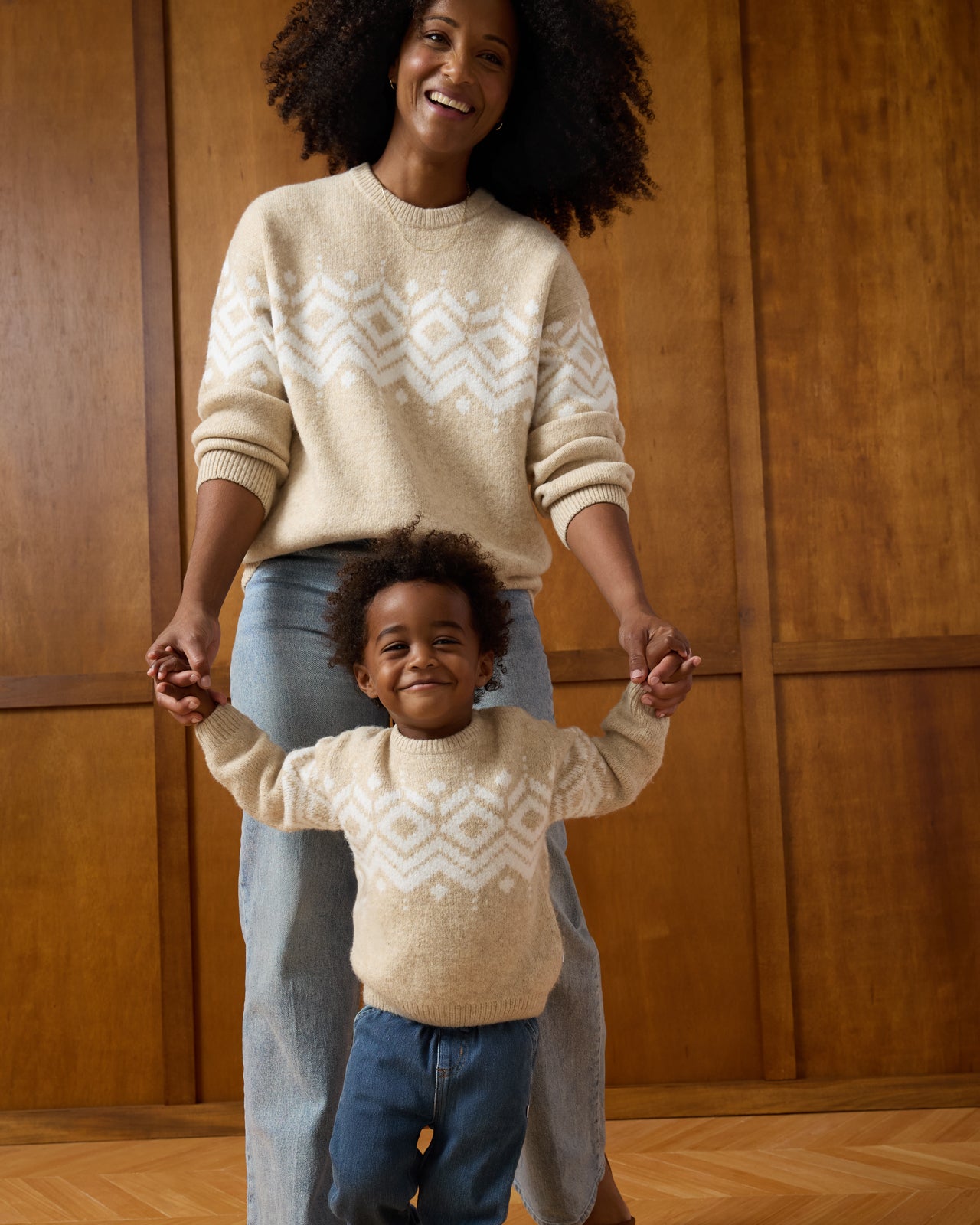 Mother and child wearing matching Neutral Fair Isle Sweaters on a brown background