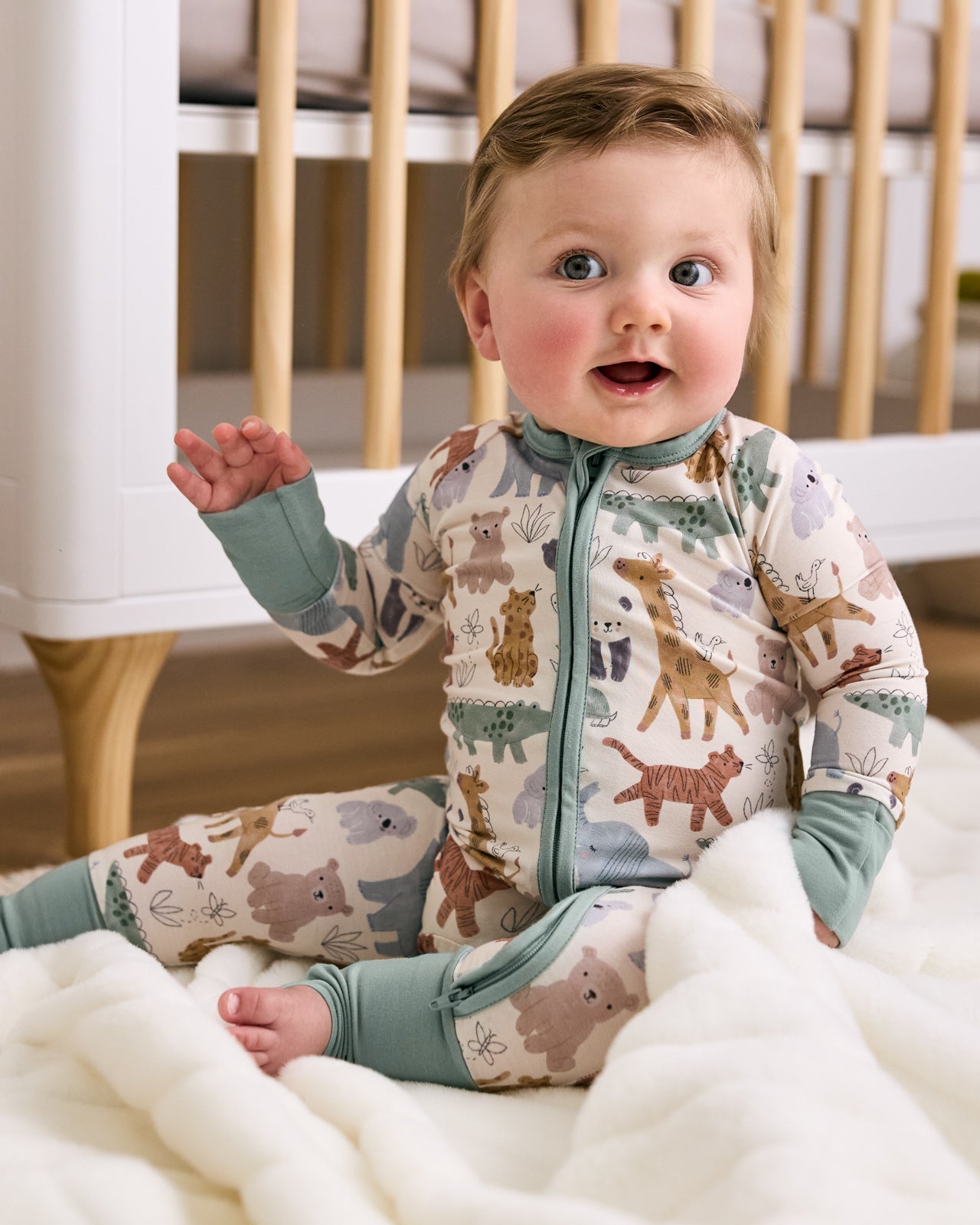 Sitting baby wearing the Sweet Safari Newborn Zippy 