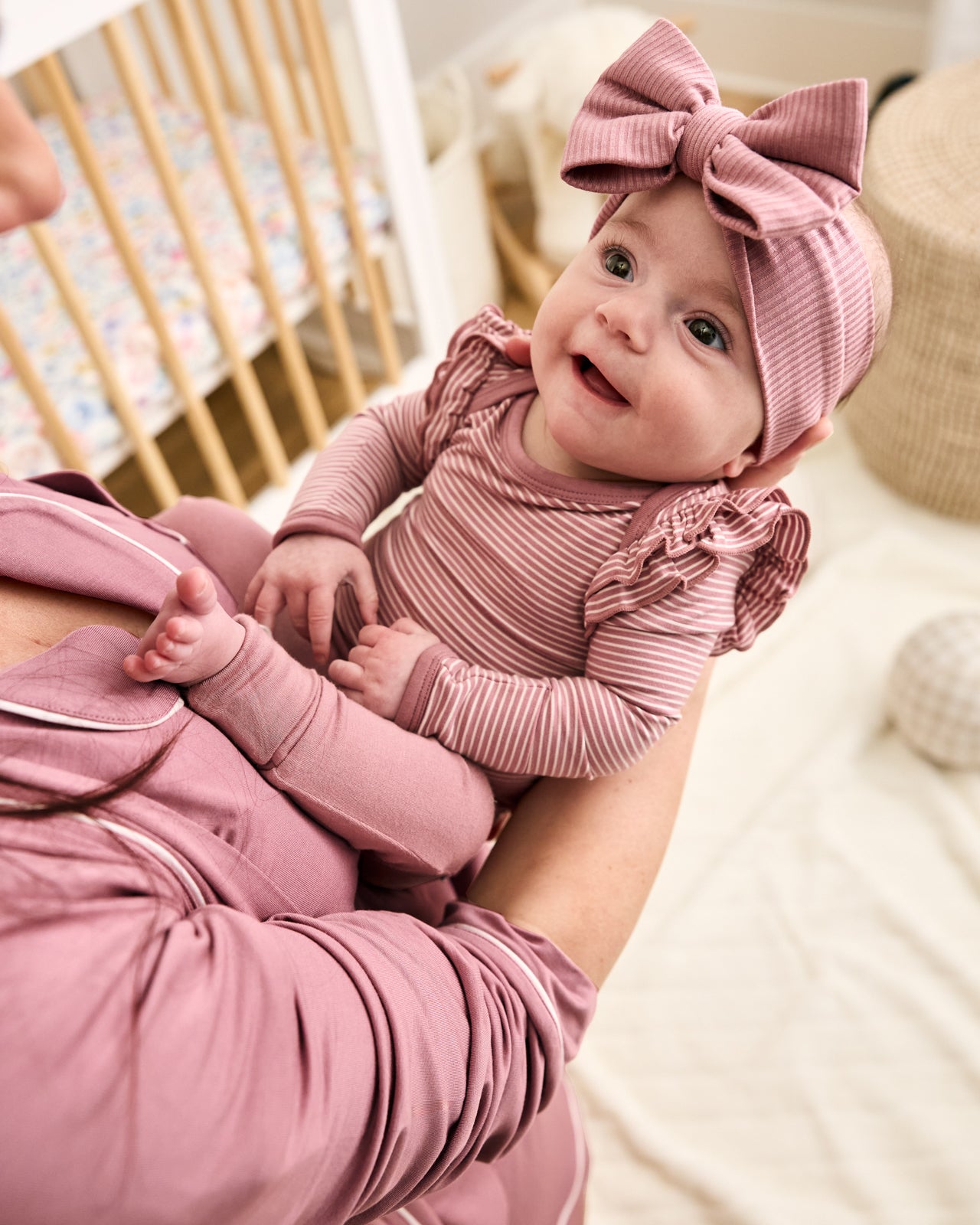 Mother holding baby wearing the Rosewood Ribbed Luxe Bow Headband