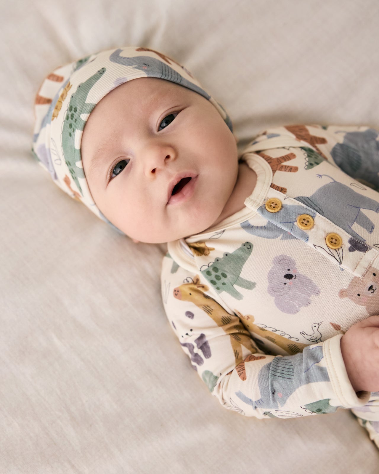 Close up of newborn wearing the Sweet Safari Henley Bodysuit with a matching infant beanie