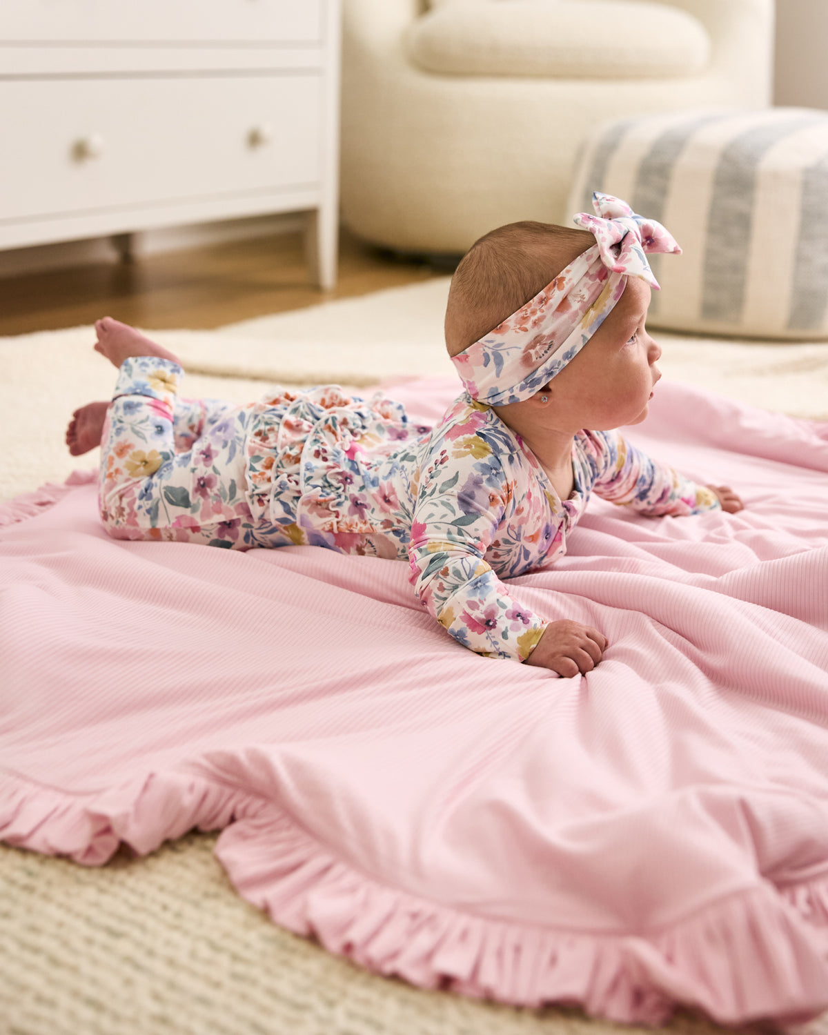 Newborn laying on the Prima Pink Ribbed Ruffle Mini Cloud Blanket