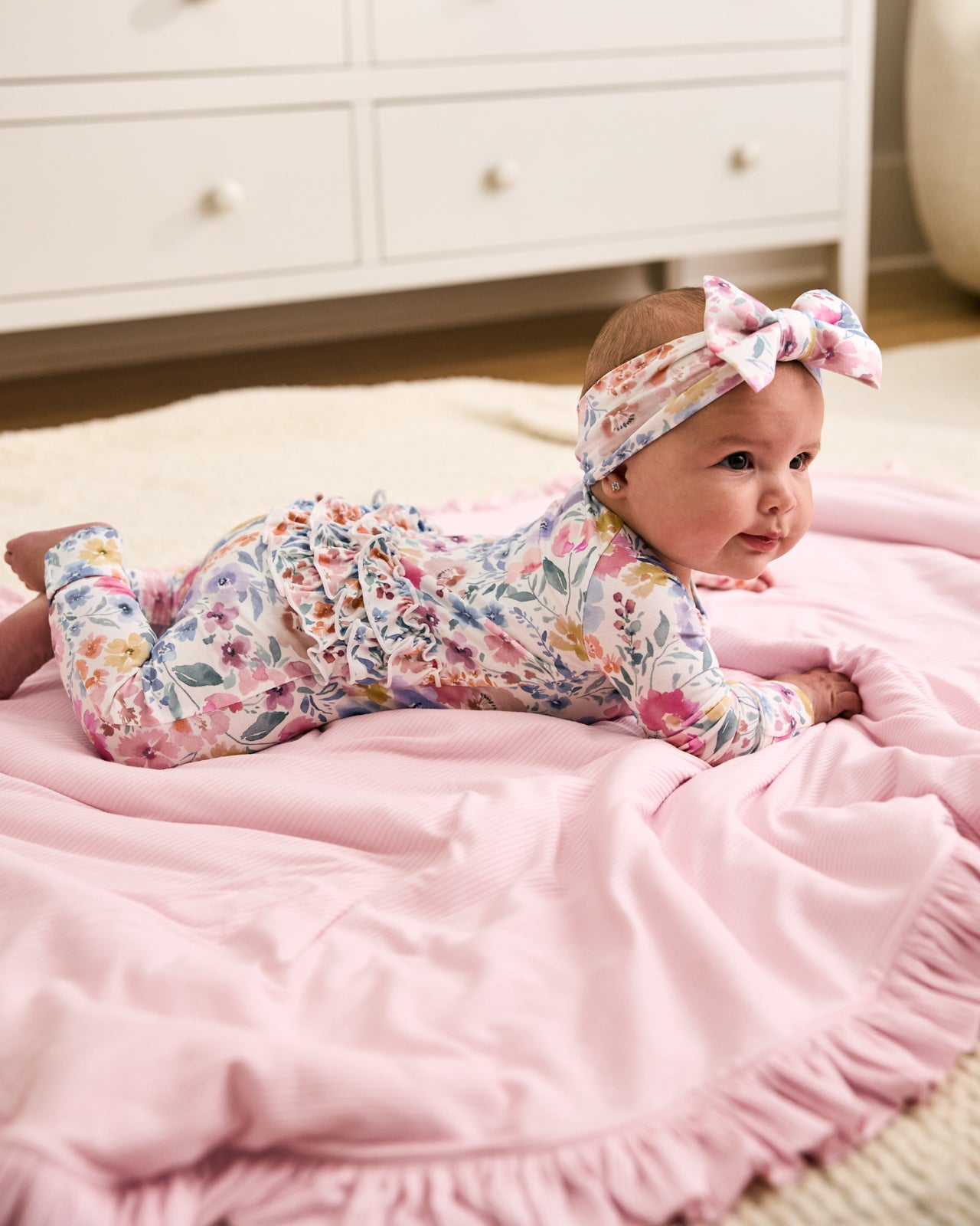 Baby laying on the Prima Pink Ribbed Ruffle Mini Cloud Blanket
