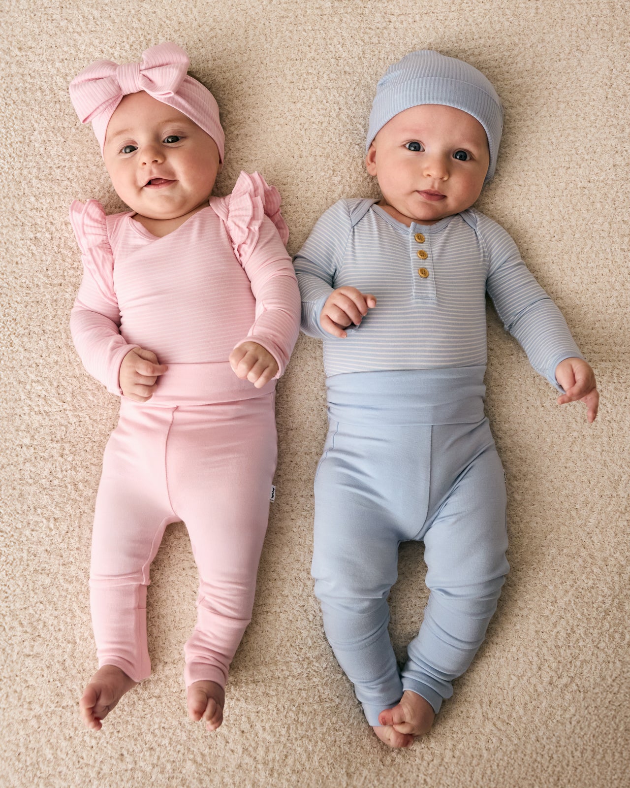 Two newborns wearing styles from the Newborn Capsule