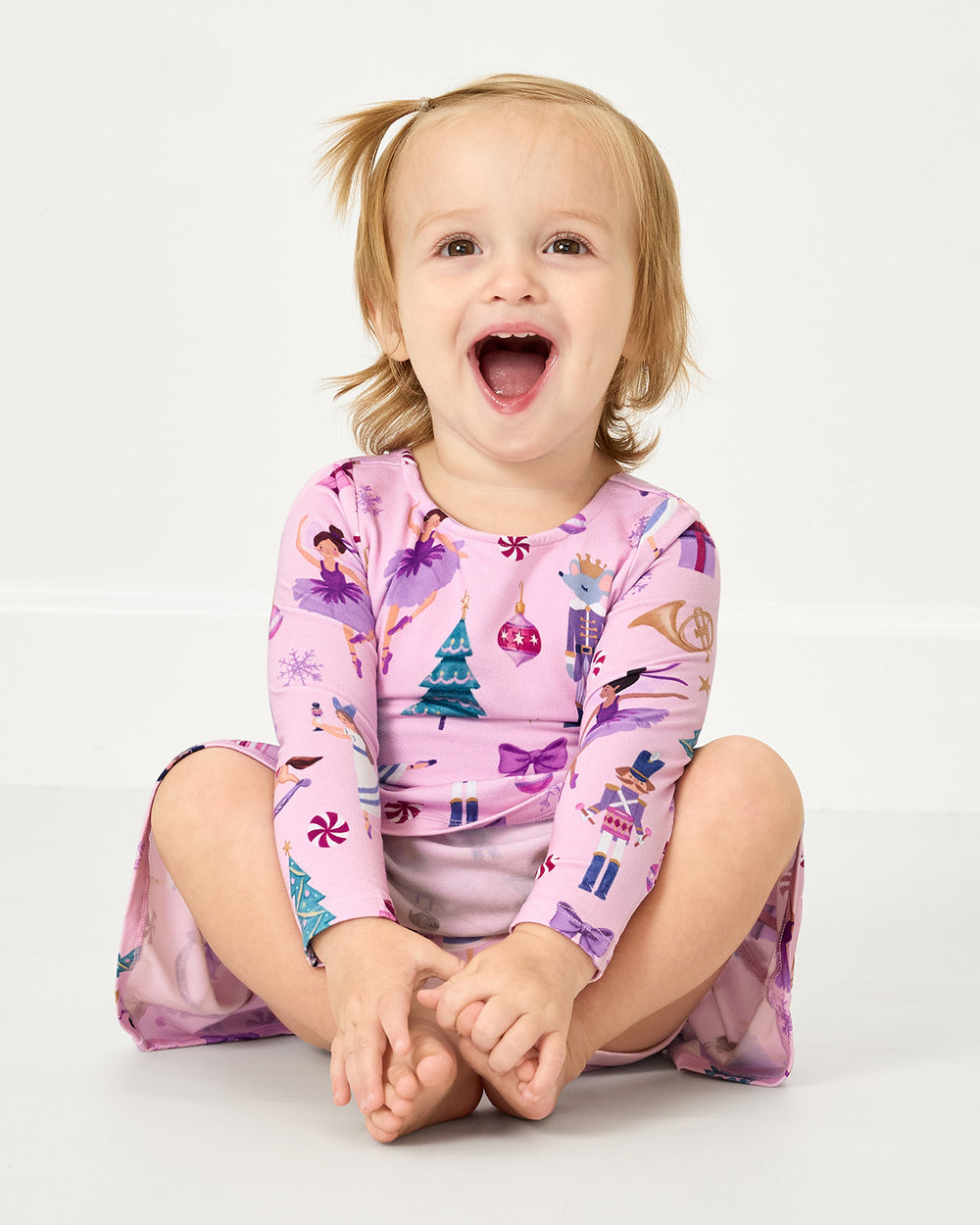 Sitting girl wearing the Nutcracker Ballet Bow Back Skater Dress with Bodysuit