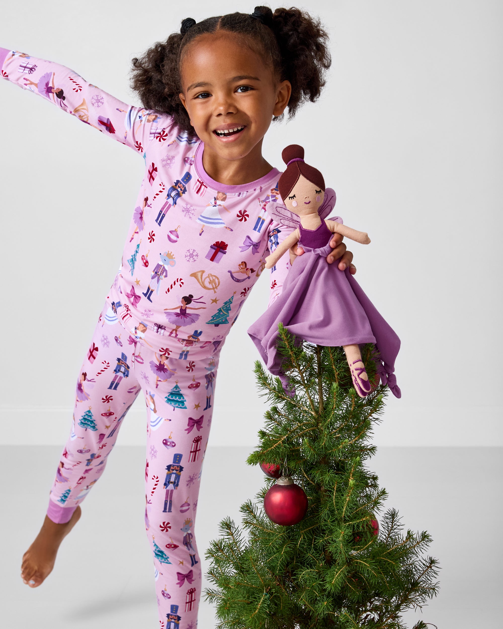 Girl holding the Marie the Sugarplum Fairy Sleepyhead Lovey on top of a tree