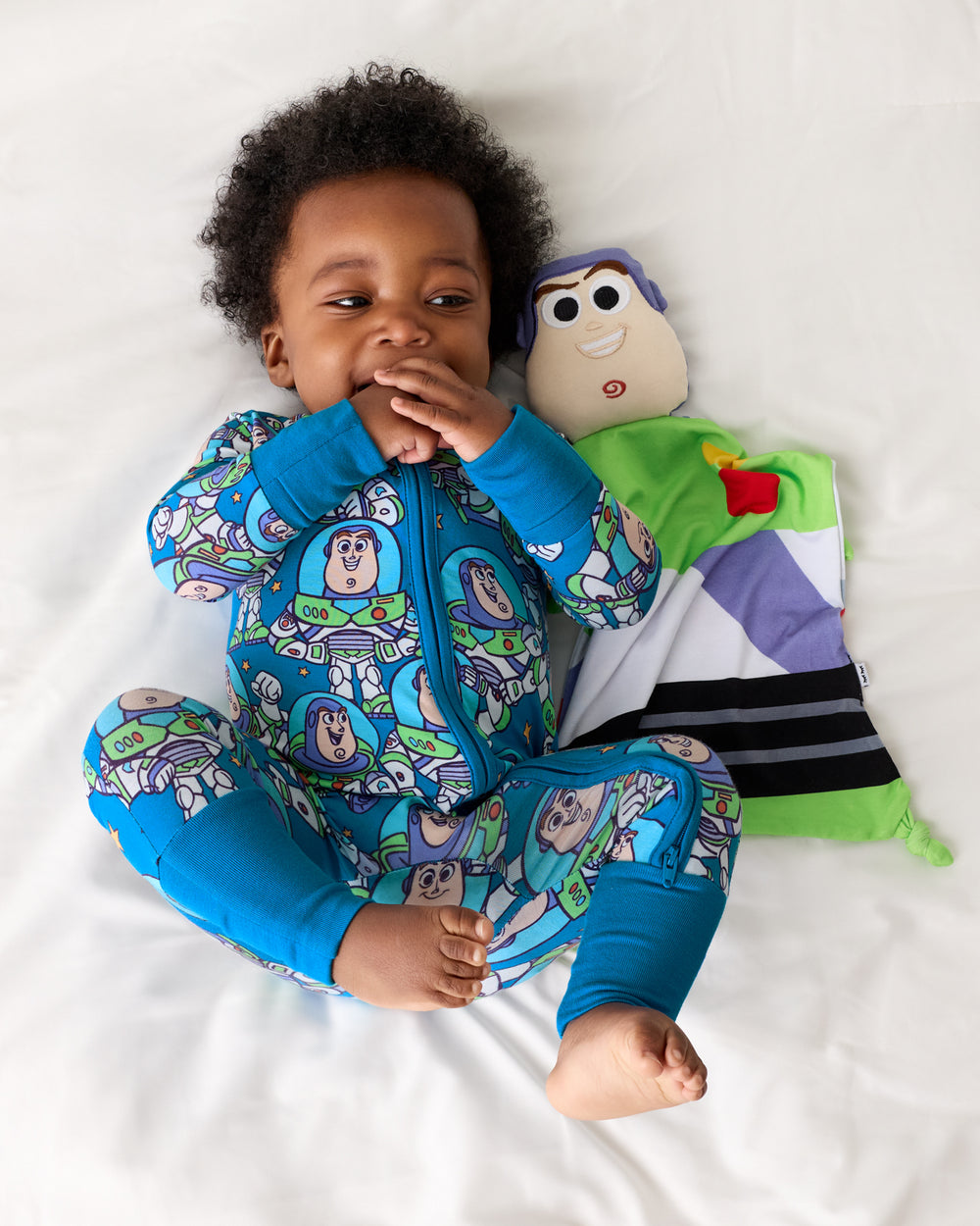 Aerial view of baby laying with the Pixar Toy Story Buzz Lightyear Lovey