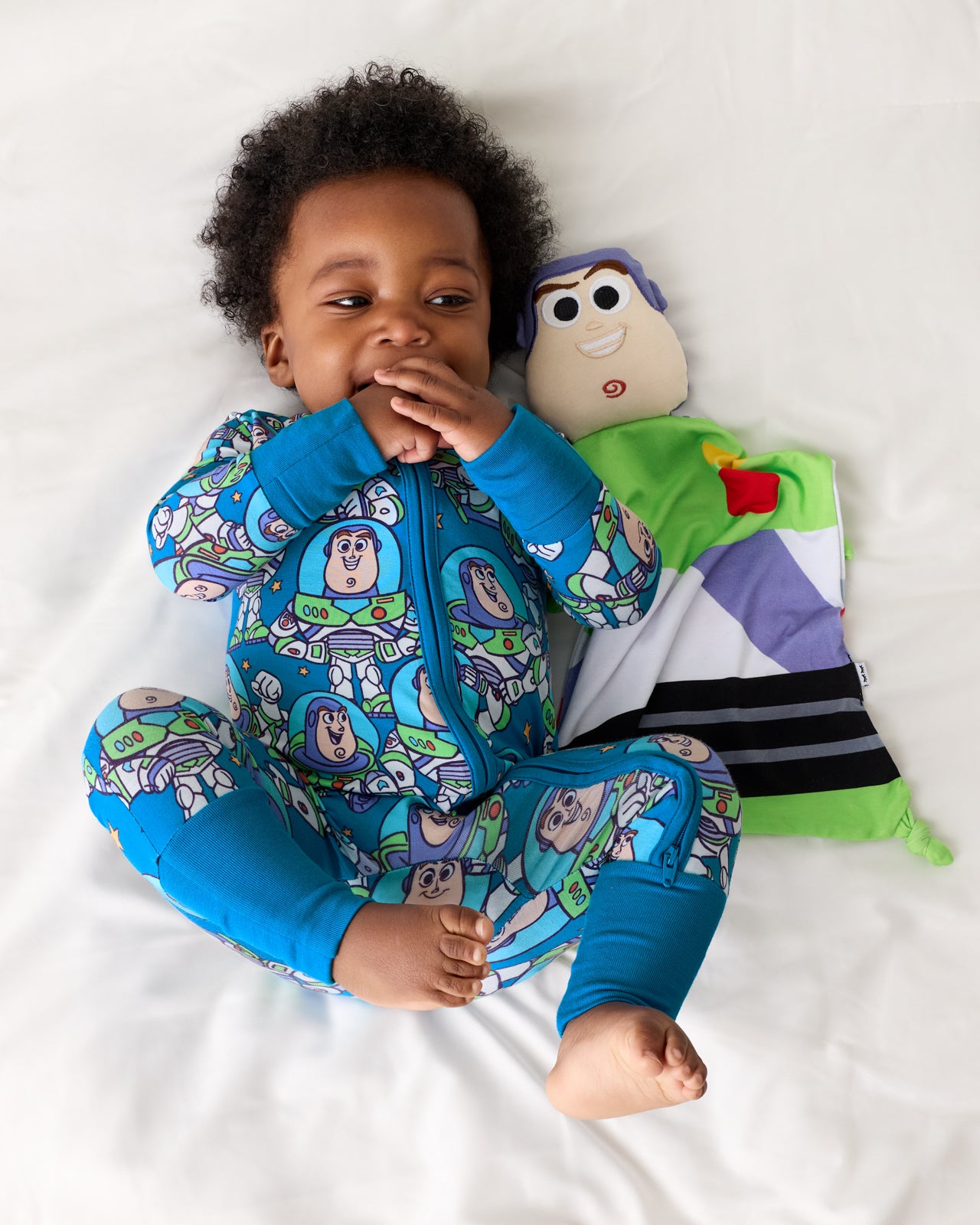 Aerial view of baby laying with the Pixar Toy Story Buzz Lightyear Lovey