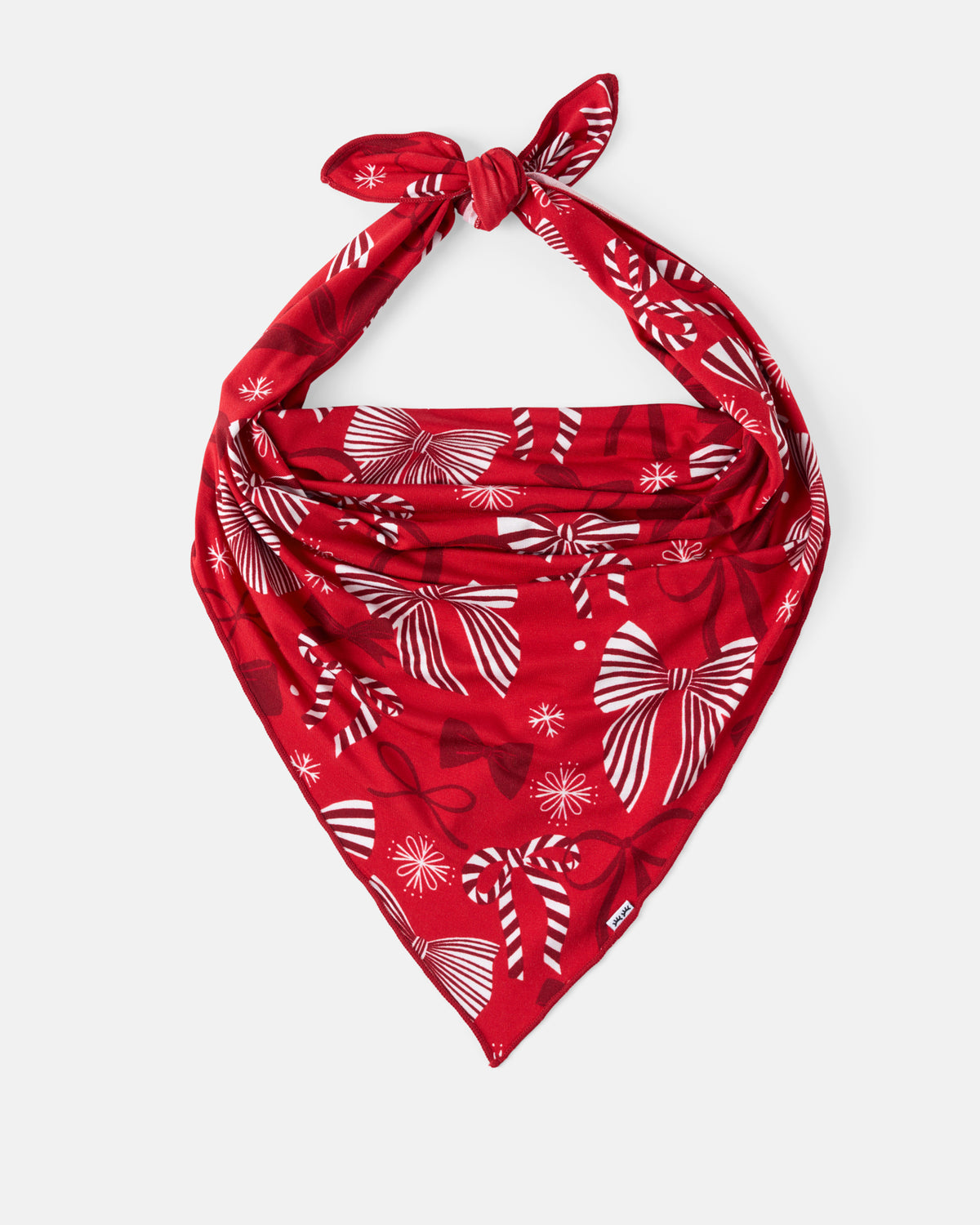 A red bandana with a white holiday-themed print of bows and snowflakes, tied in a knot at the top and displayed against a light gray background.