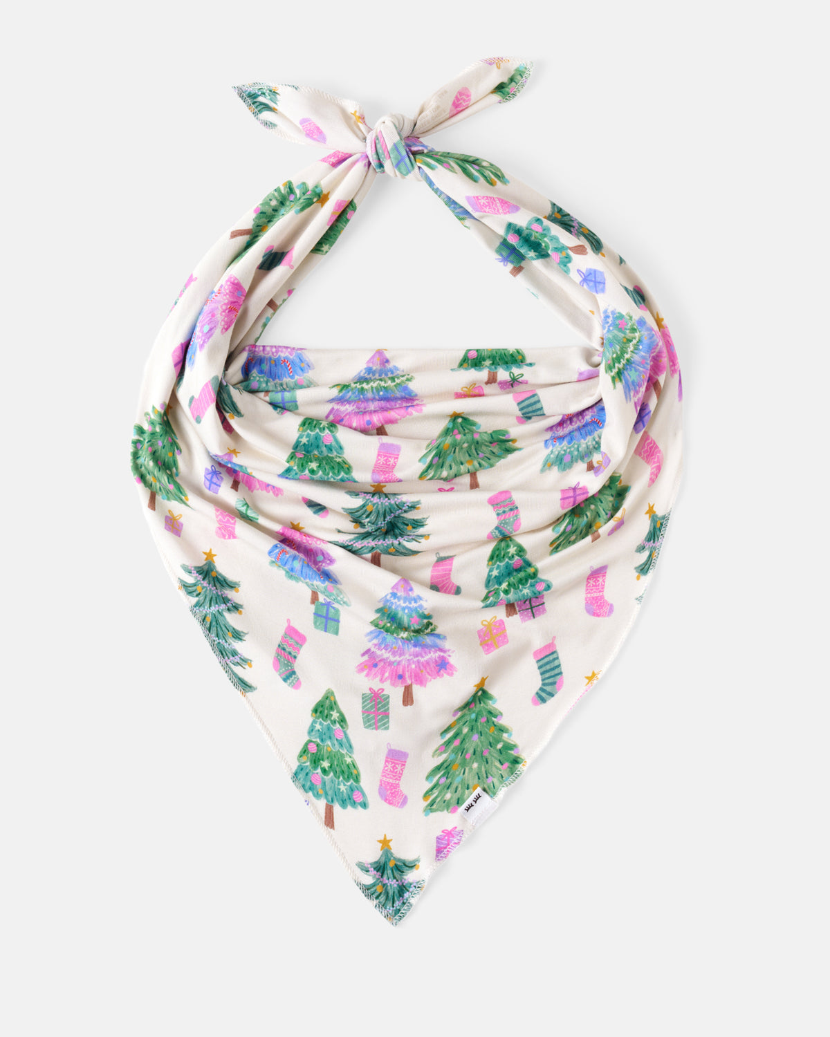 A cream-colored bandana or scarf with a festive Christmas print, featuring green Christmas trees, pink stockings, and gift boxes, tied in a knot at the top against a light gray background.
