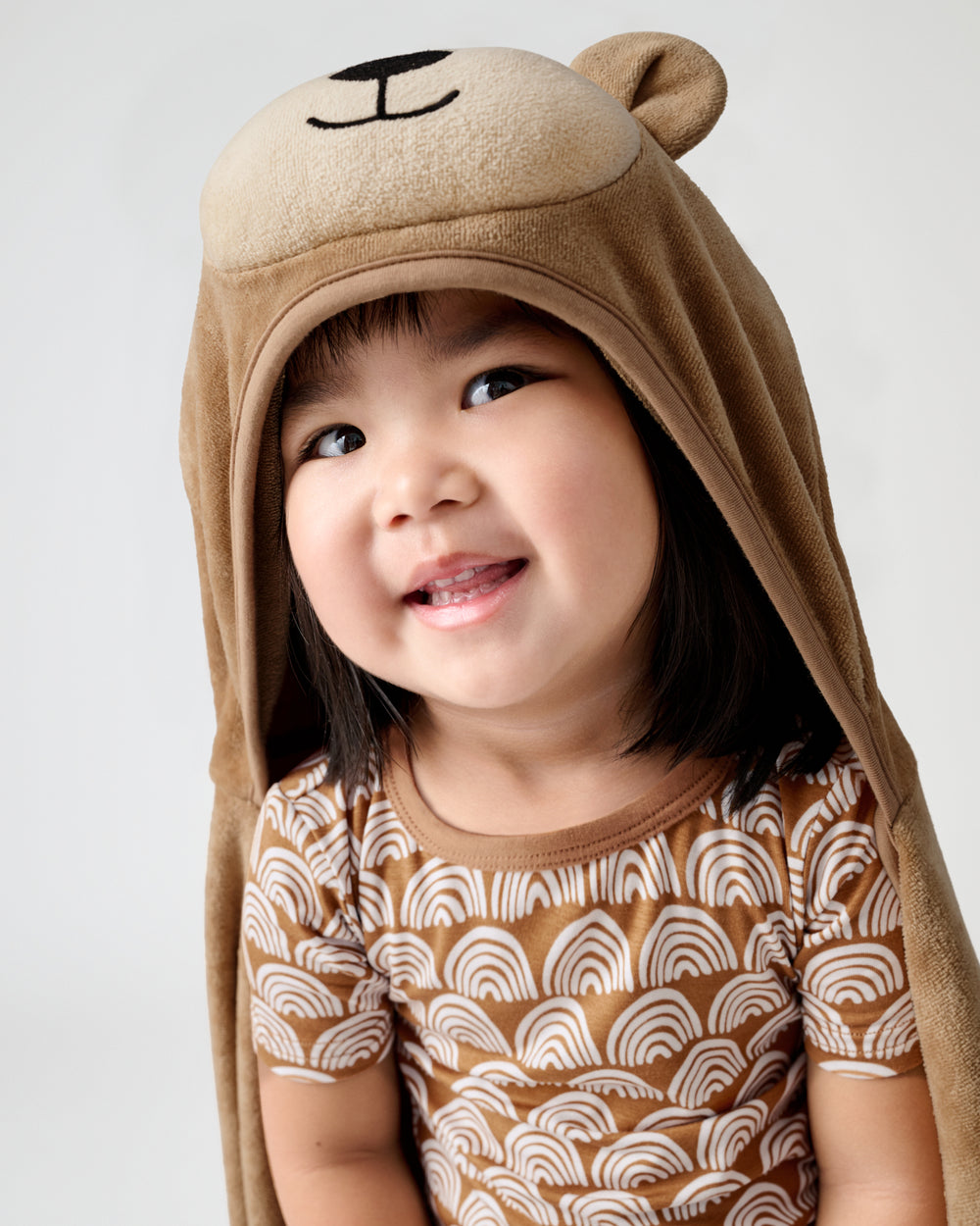 Close up of young girl wearing a hooded bear towel over her head