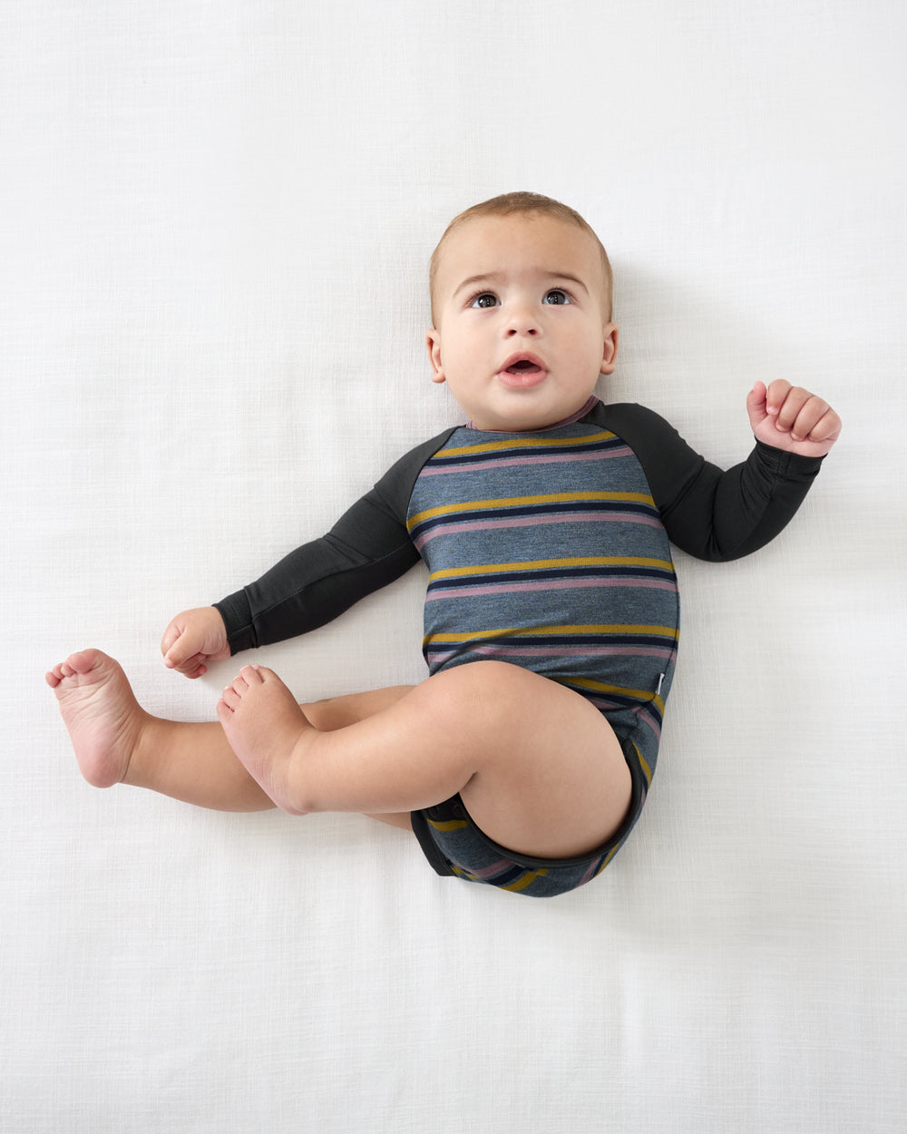Aerial view of baby wearing the Ollie Stripe Raglan Bodysuit