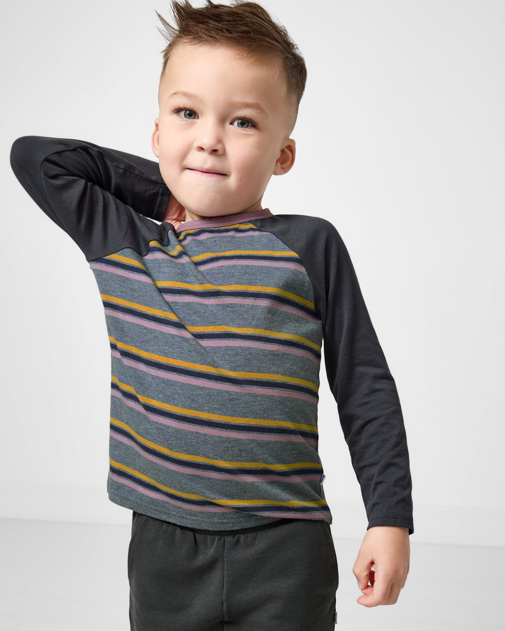 Close up of boy wearing the Ollie Stripe Raglan Tee