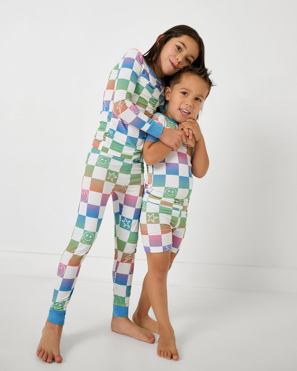 Two kids wearing matching Ombre Cheery Checks Two-Piece Pajama Sets