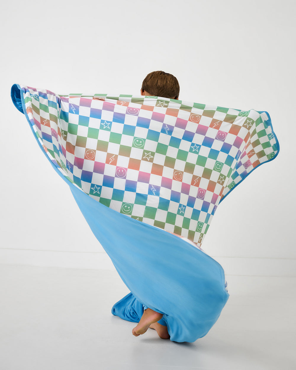 Child in motion holding up the Ombre Cheery Checks Large Cloud Blanket®