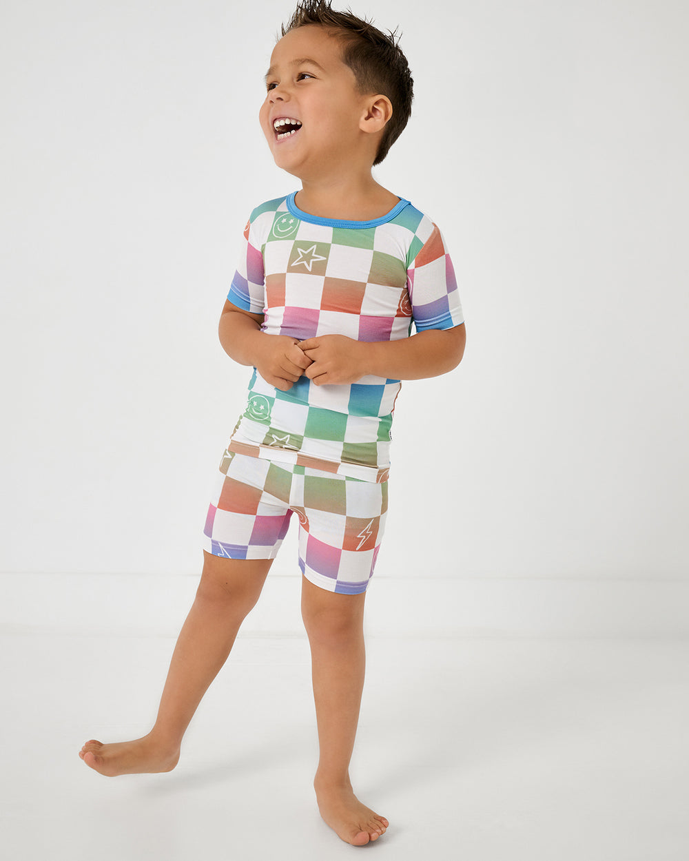 Standing boy wearing the Ombre Cheery Checks Two-Piece Short Sleeve & Shorts Pajama Set