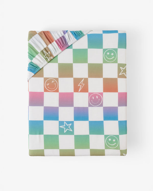 Flat lay of the Ombre Cheery Checks Fitted Crib Sheet