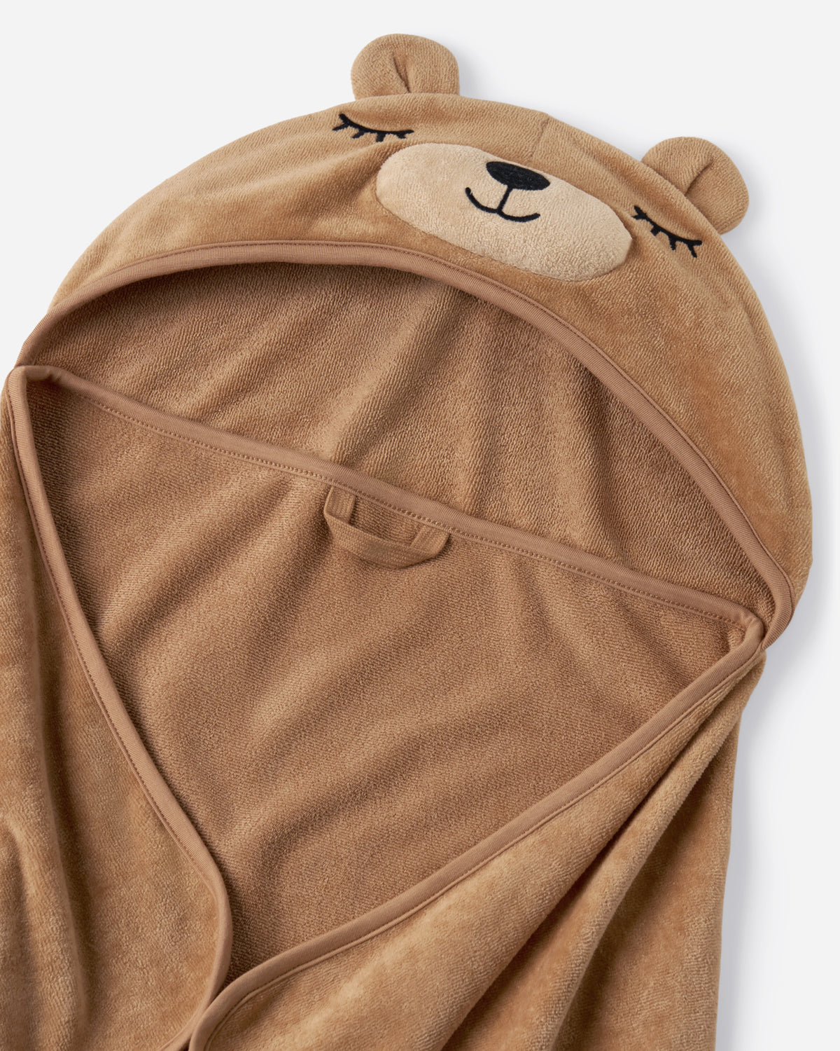 A plush brown hooded towel or blanket with a bear face design on the hood, shown against a light gray background.