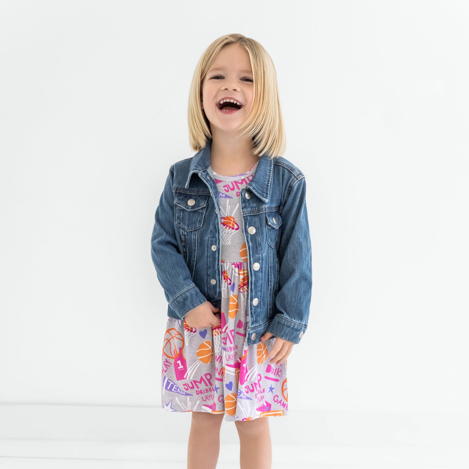 Child wearing the Pink Slam Dunk Skater Dress with a denim trucker jacket
