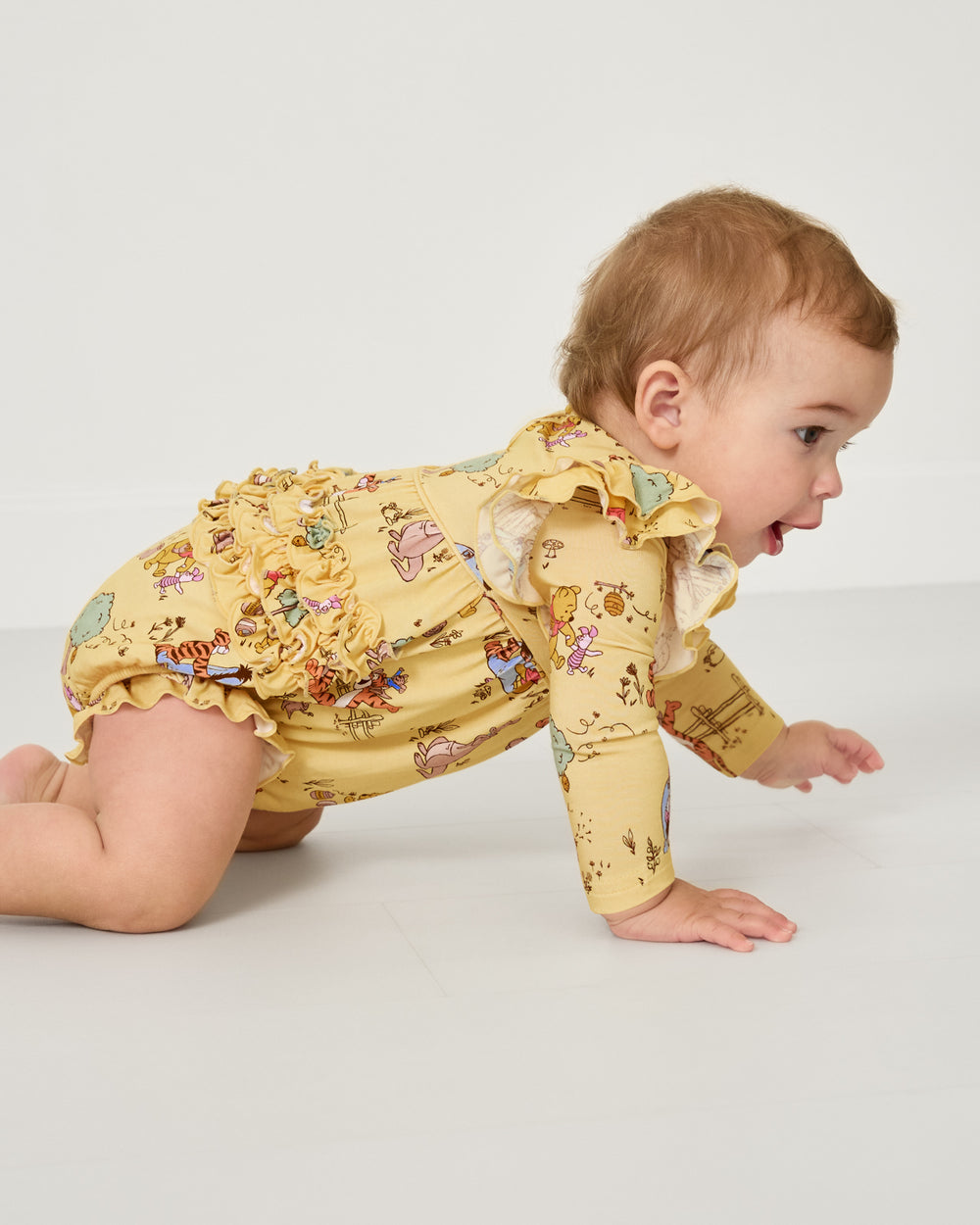 Crawling baby wearing the Disney Playtime With Pooh Bubble Romper