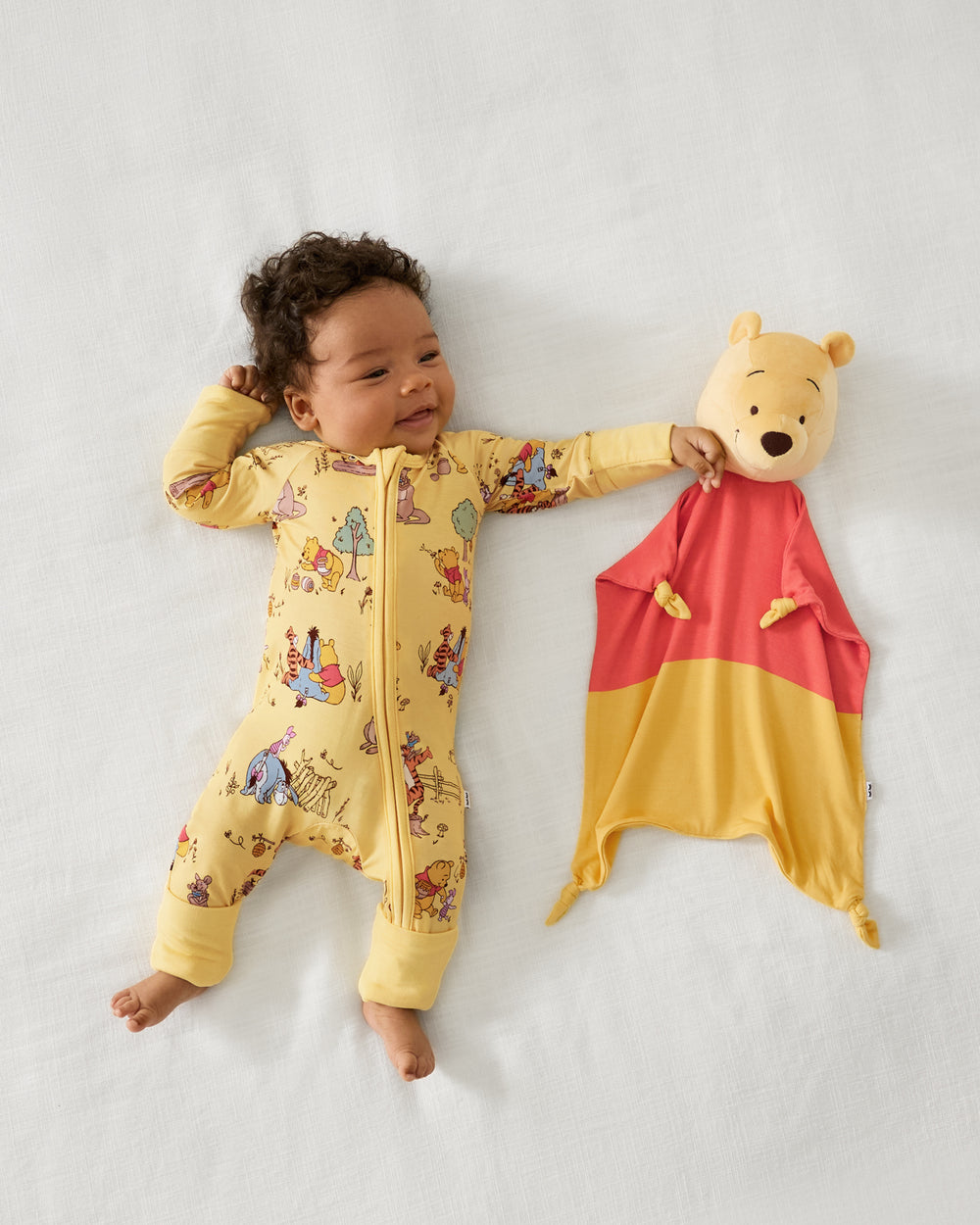 Baby laying with the Disney Winnie The Pooh Lovey
