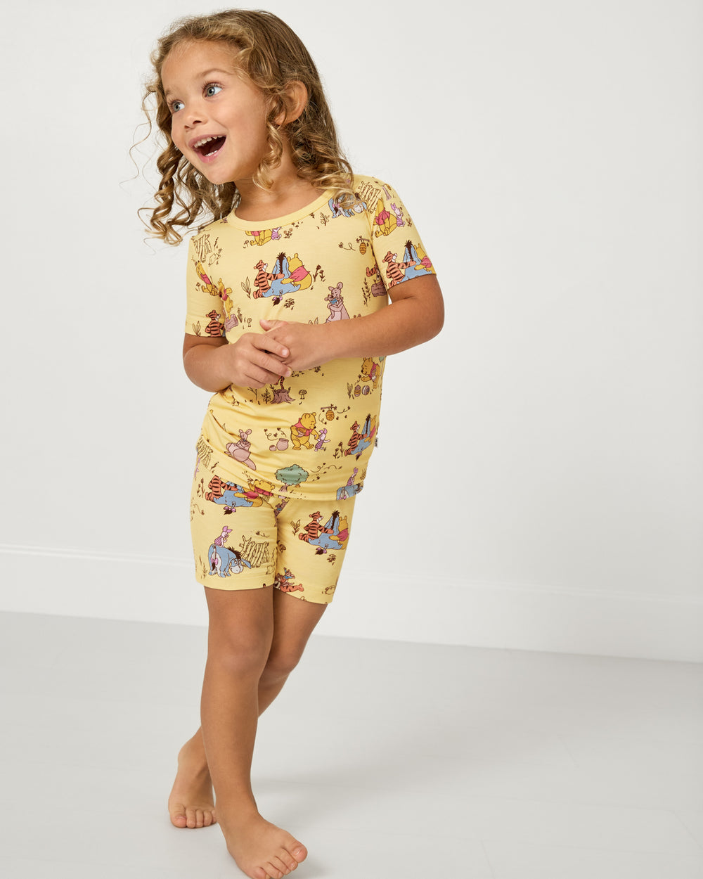 Girl wearing the Disney Playtime With Pooh Two-Piece Short Sleeve & Shorts Pajama Set