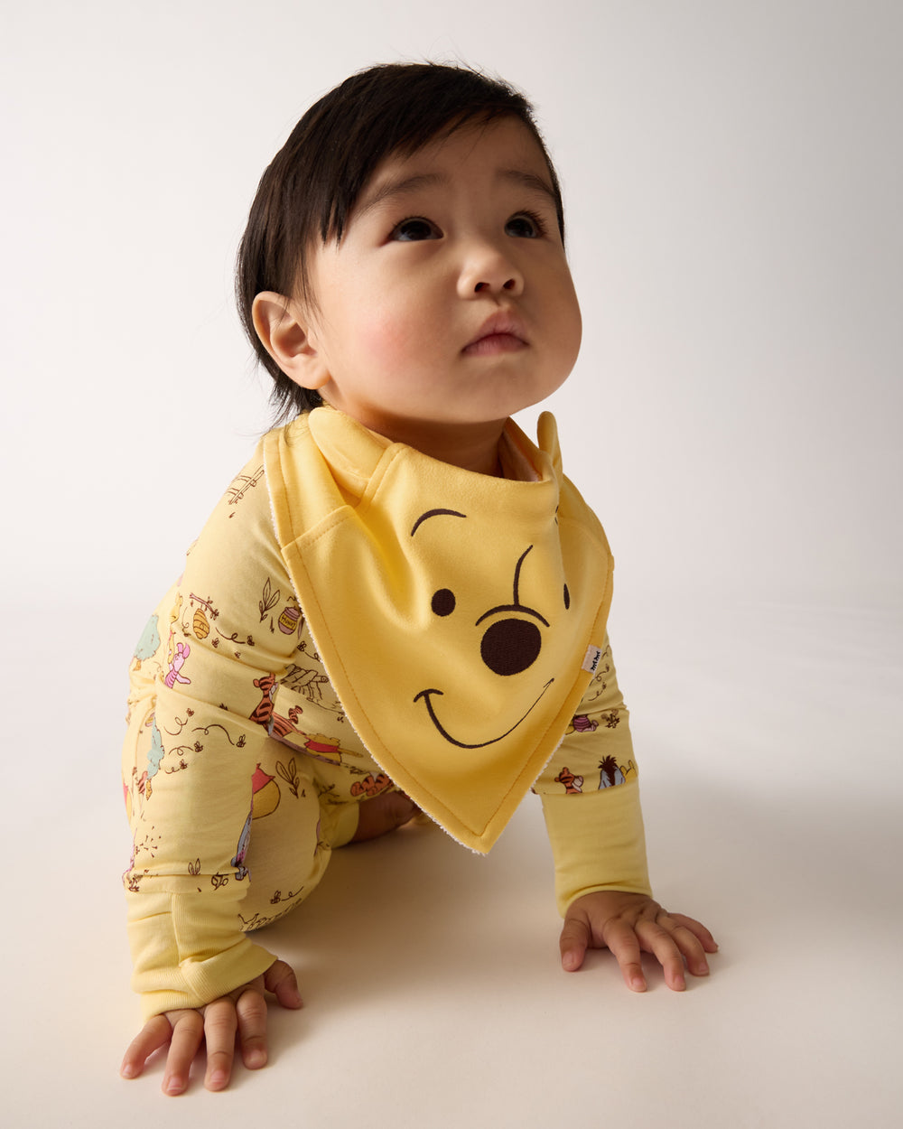 Crawling baby wearing the Disney Winnie The Pooh Bandana Bib