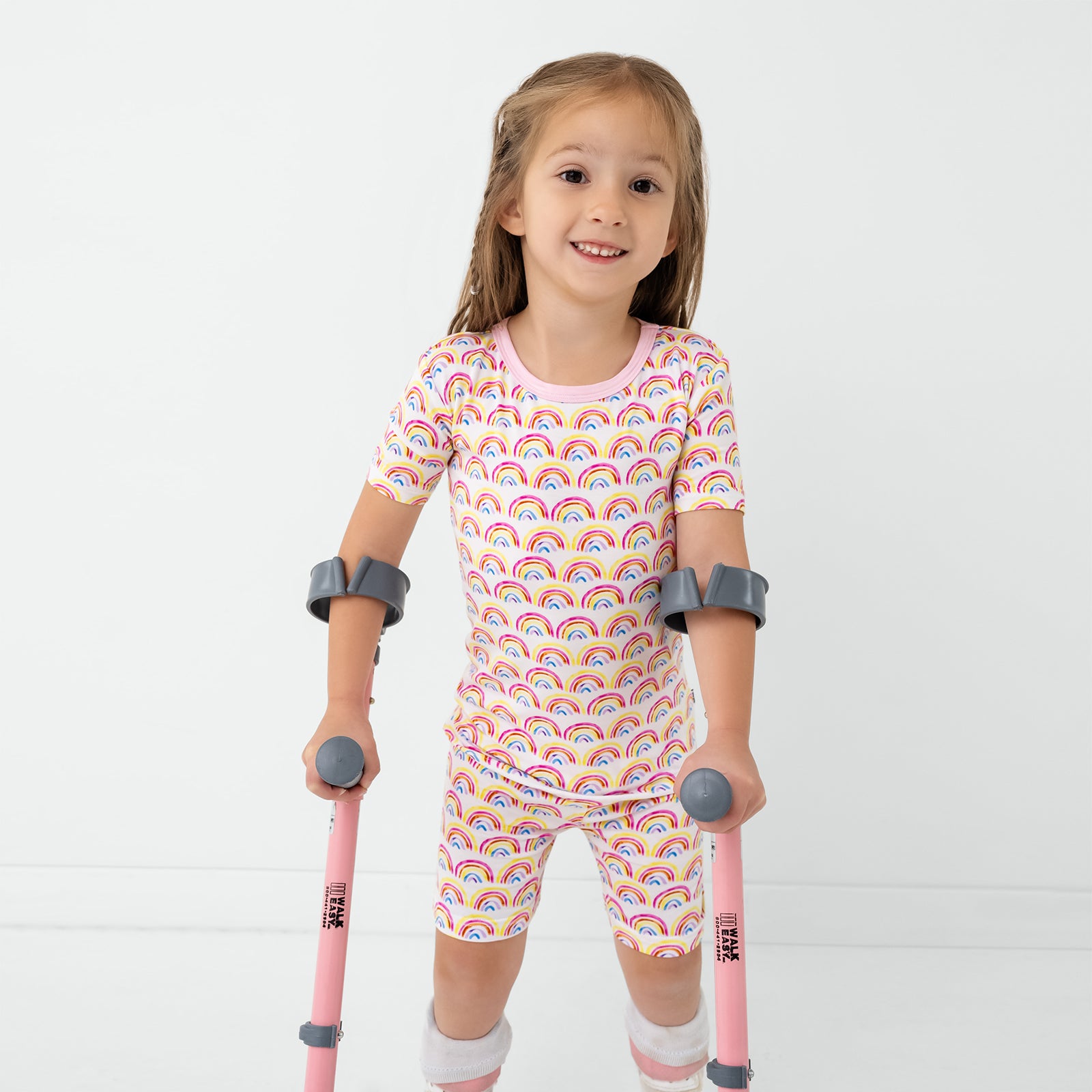 Girl wearing the Pastel Rainbows Two-Piece Short Sleeve & Shorts Pajama Set