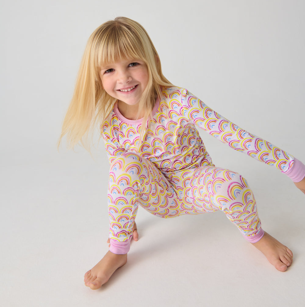 Crouching child wearing the Pastel Rainbows Two-Piece Pajama Set