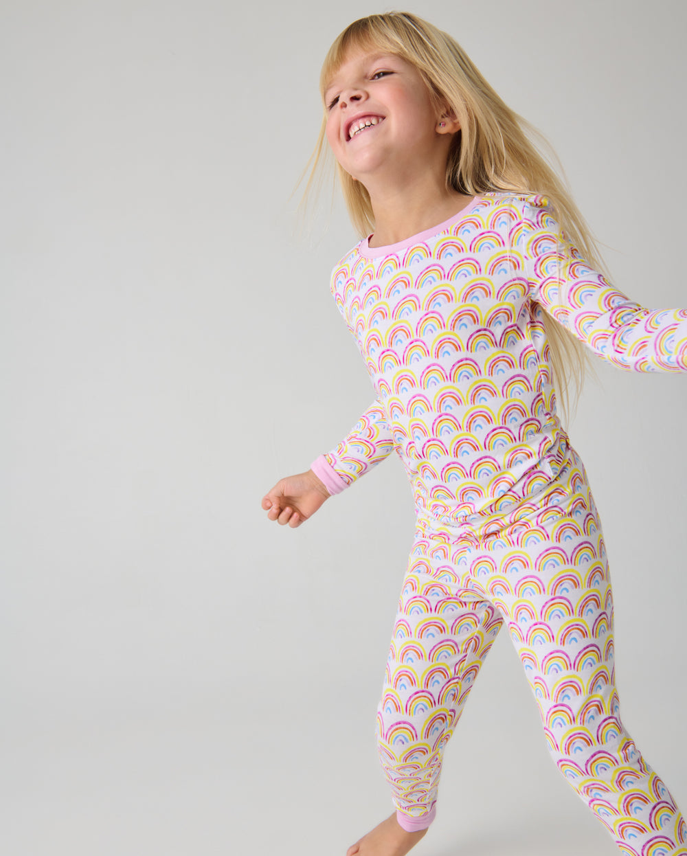Girl wearing the Pastel Rainbows Two-Piece Pajama Set
