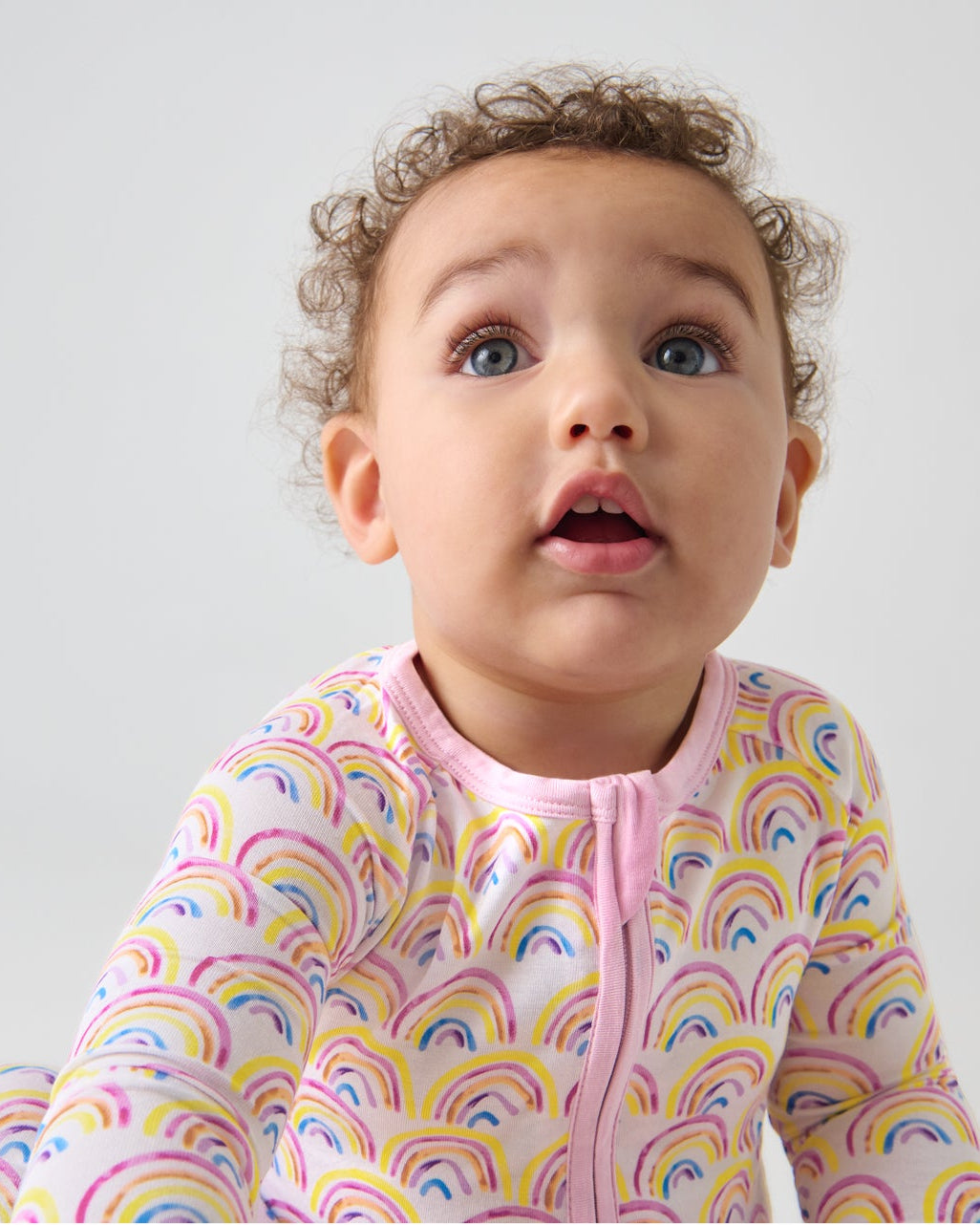 Close up of baby wearing the Pastel Rainbows Zippy
