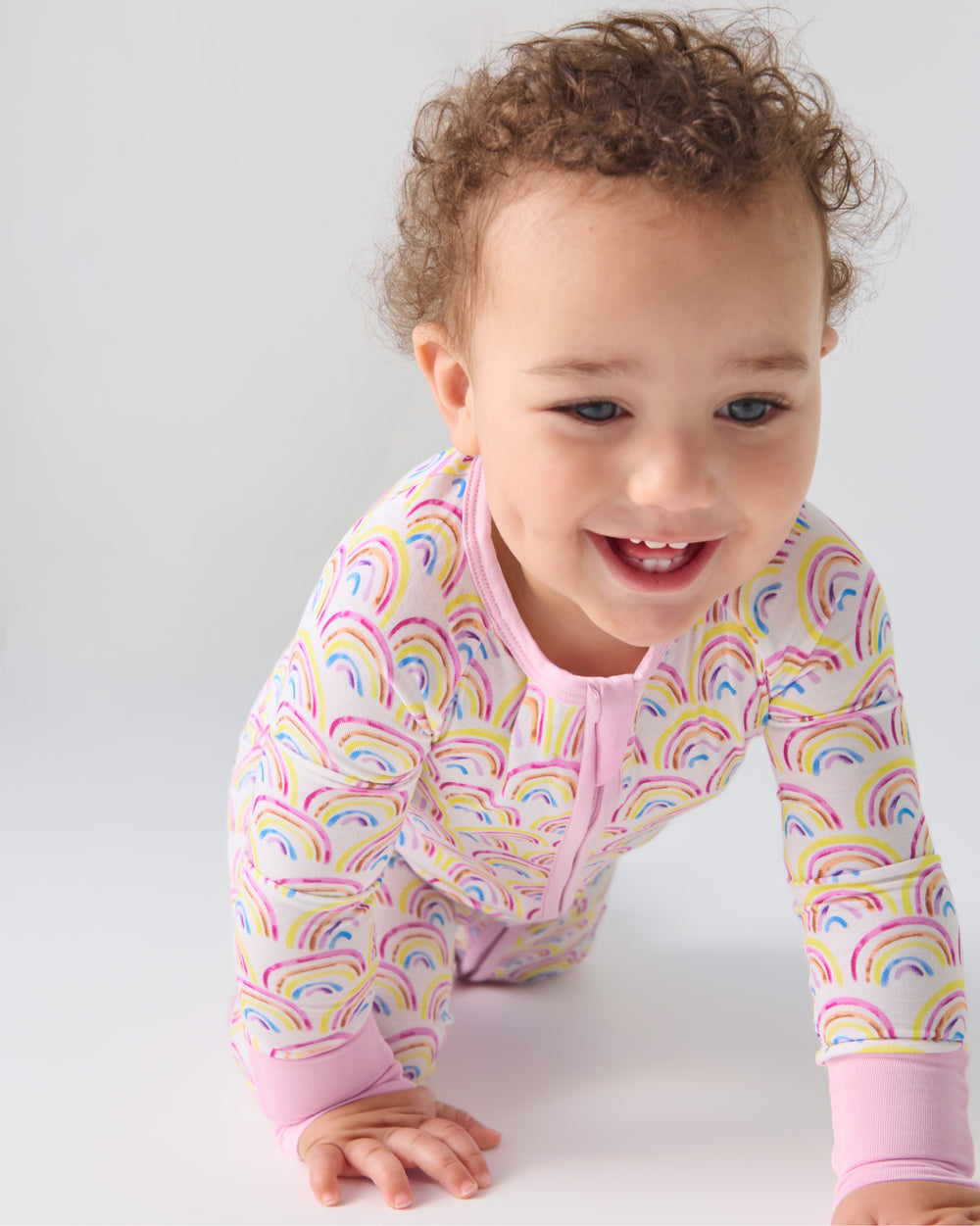 Crawling baby wearing the Pastel Rainbows Zippy
