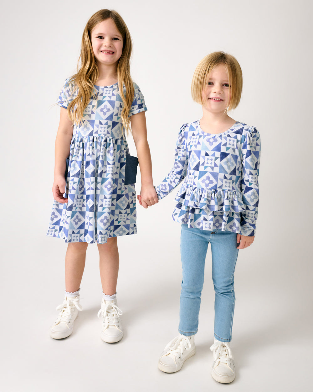 Two girls holding hands wearing matching Patchwork Indigo play styles