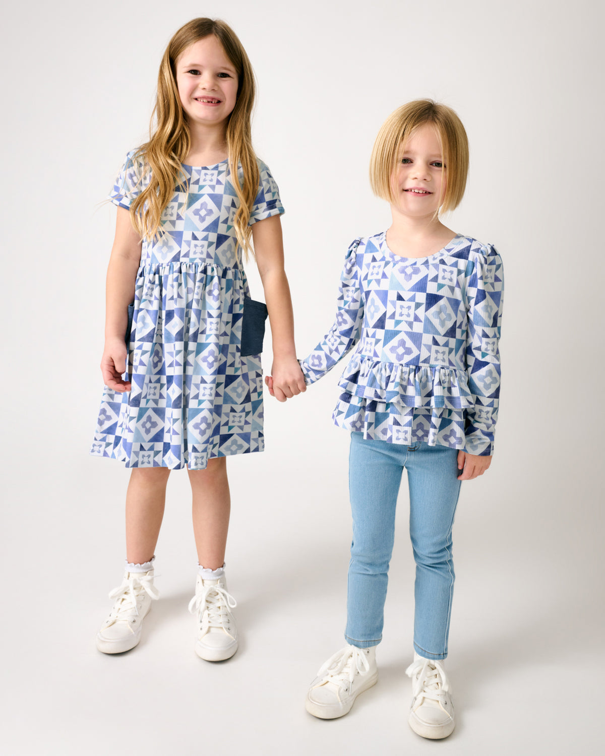 Two girls holding hands wearing matching Patchwork Indigo play styles