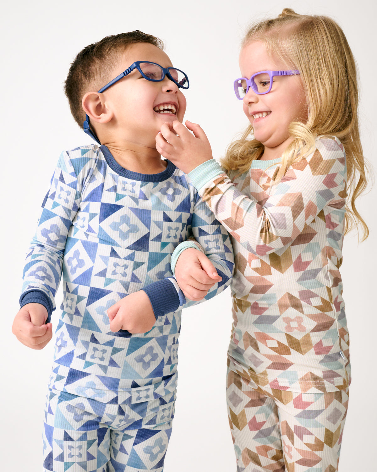 Two children wearing abstract print pajamas