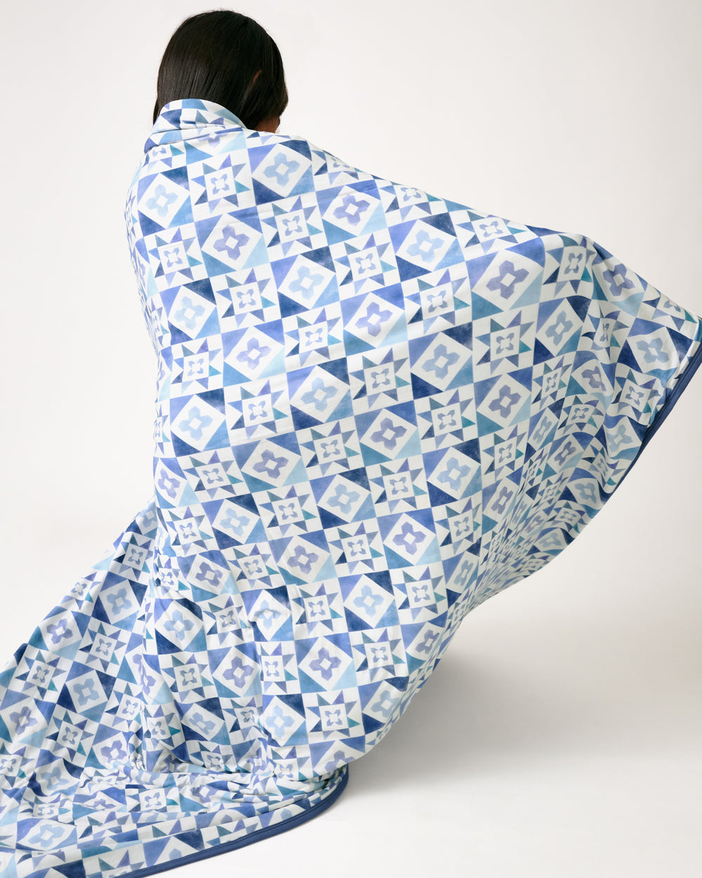 Child in motion wrapped in the Patchwork Indigo Large Cloud Blanket® 